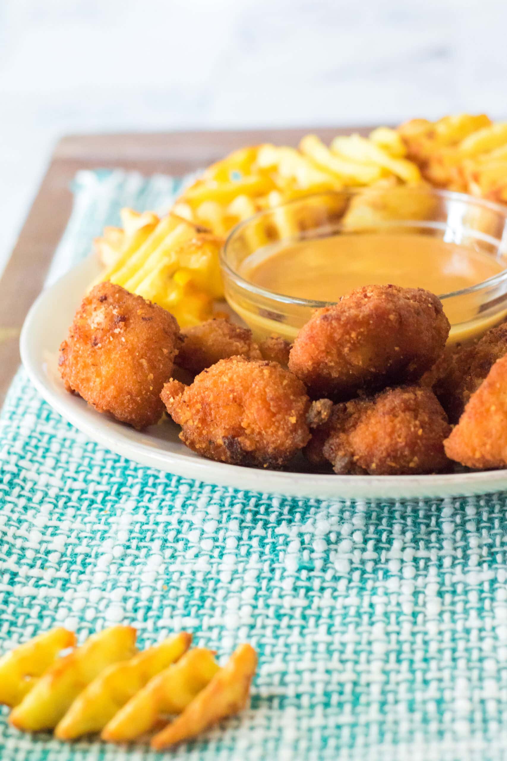 Chick Fil A sauce all made in a bowl, surrounded with Chick Fil A nuggets and waffle fries