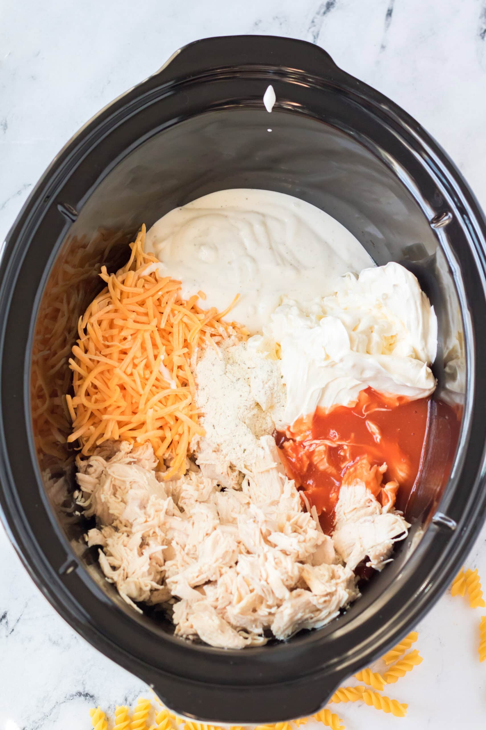Chicken ,cream cheese, hot sauce, ranch dressing, ranch dry mix, and cheddar cheese to crockpot