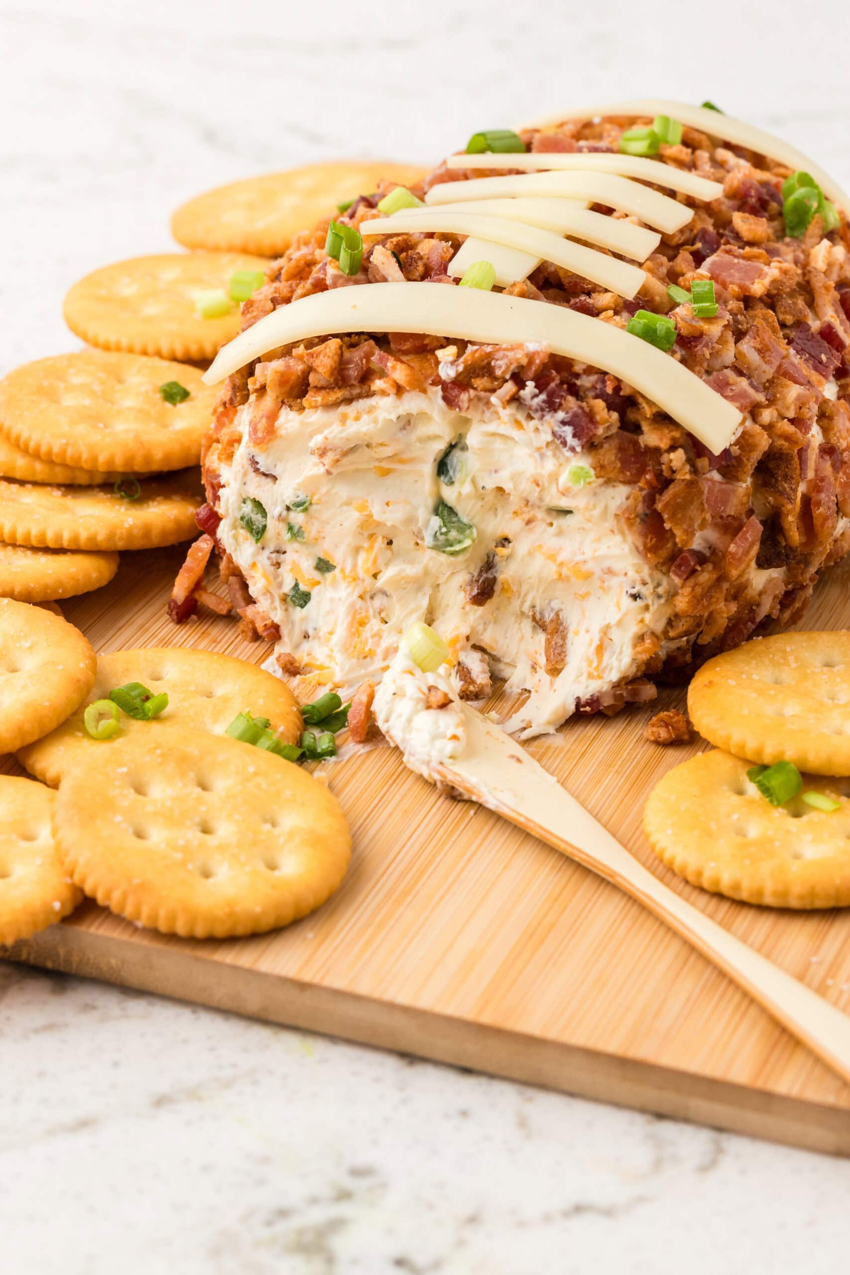 Football cheeseball is cut in half to show the inside and it's texture in ingredients