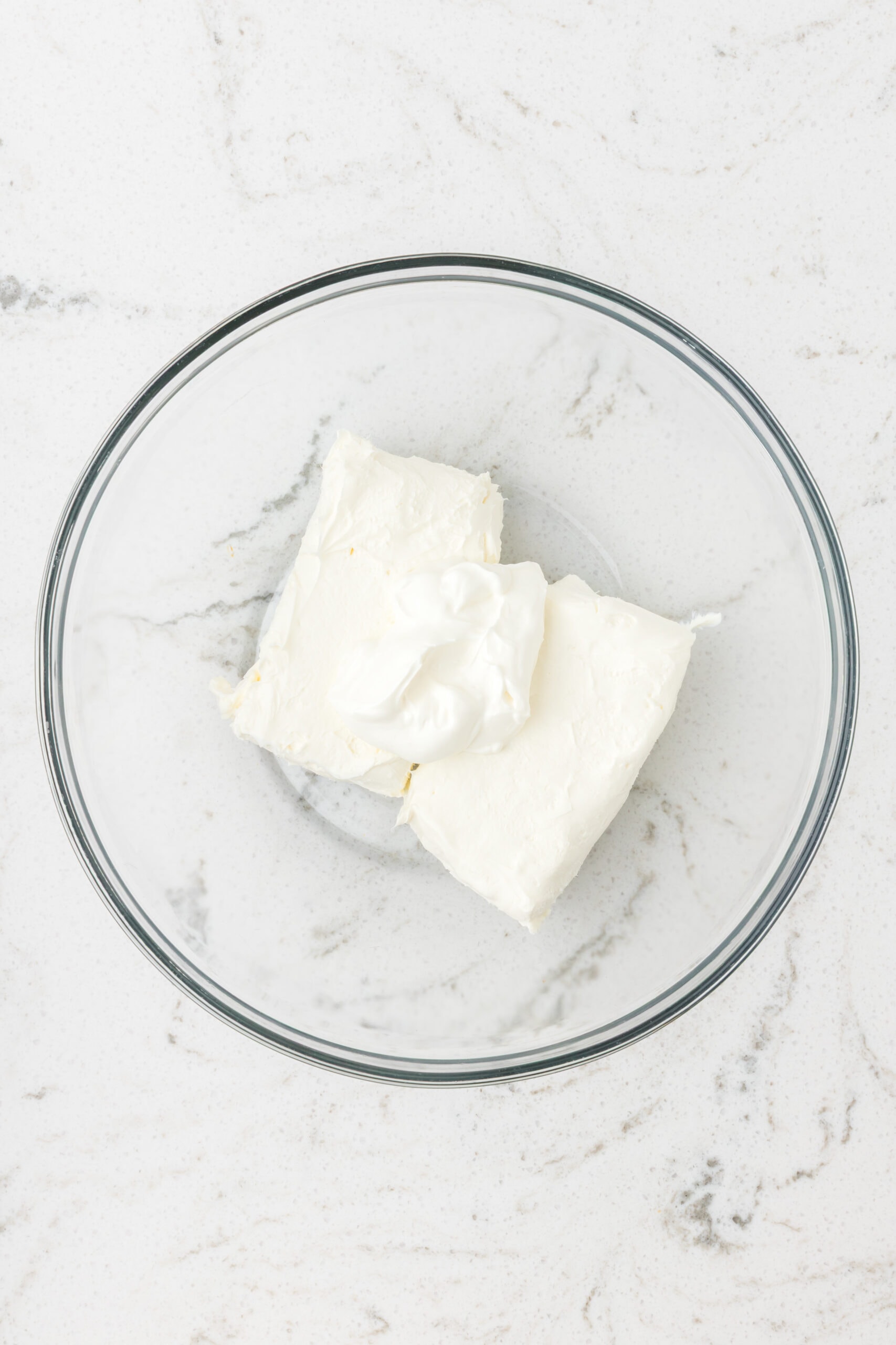 Softened cream cheese and sour cream in a bowl, ready to be mixed