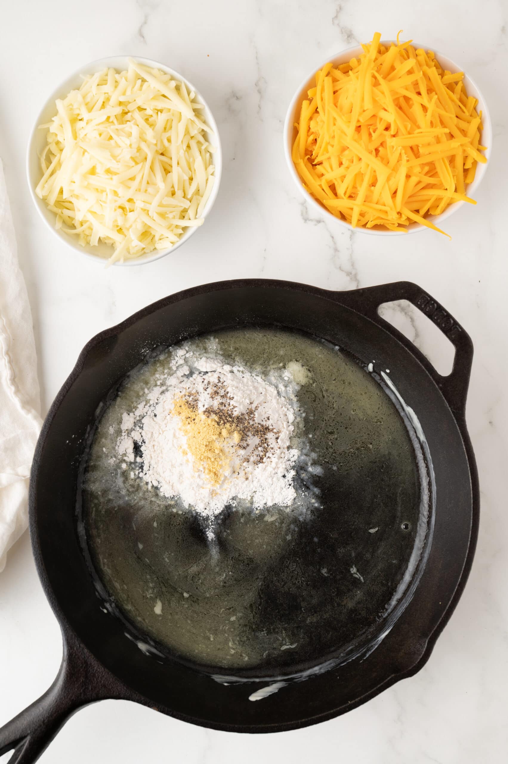 Adding flour and spices to melted butter to start making the roux