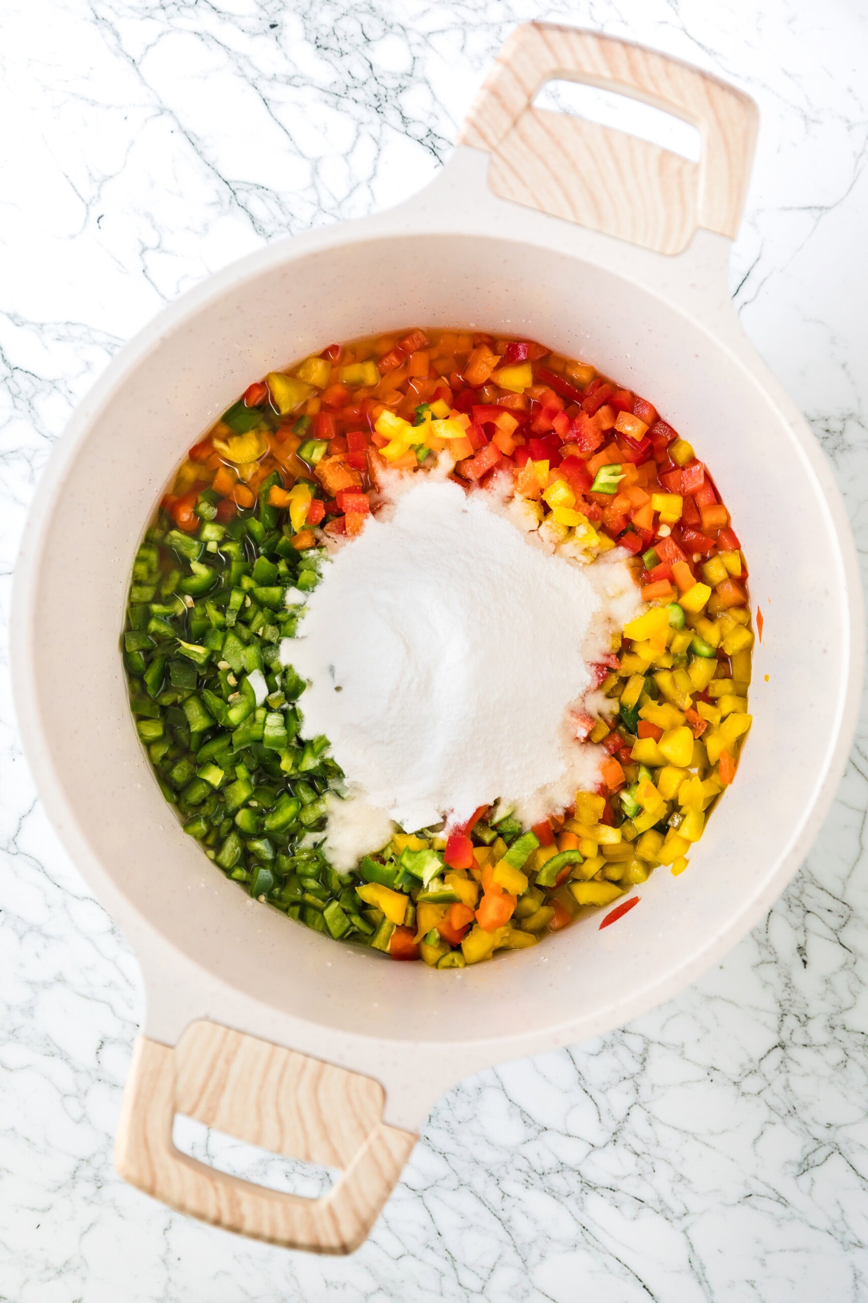 Adding all ingredients to a large pot: jalapenos, bell peppers, apple cider vinegar, white vinegar, powder pectin