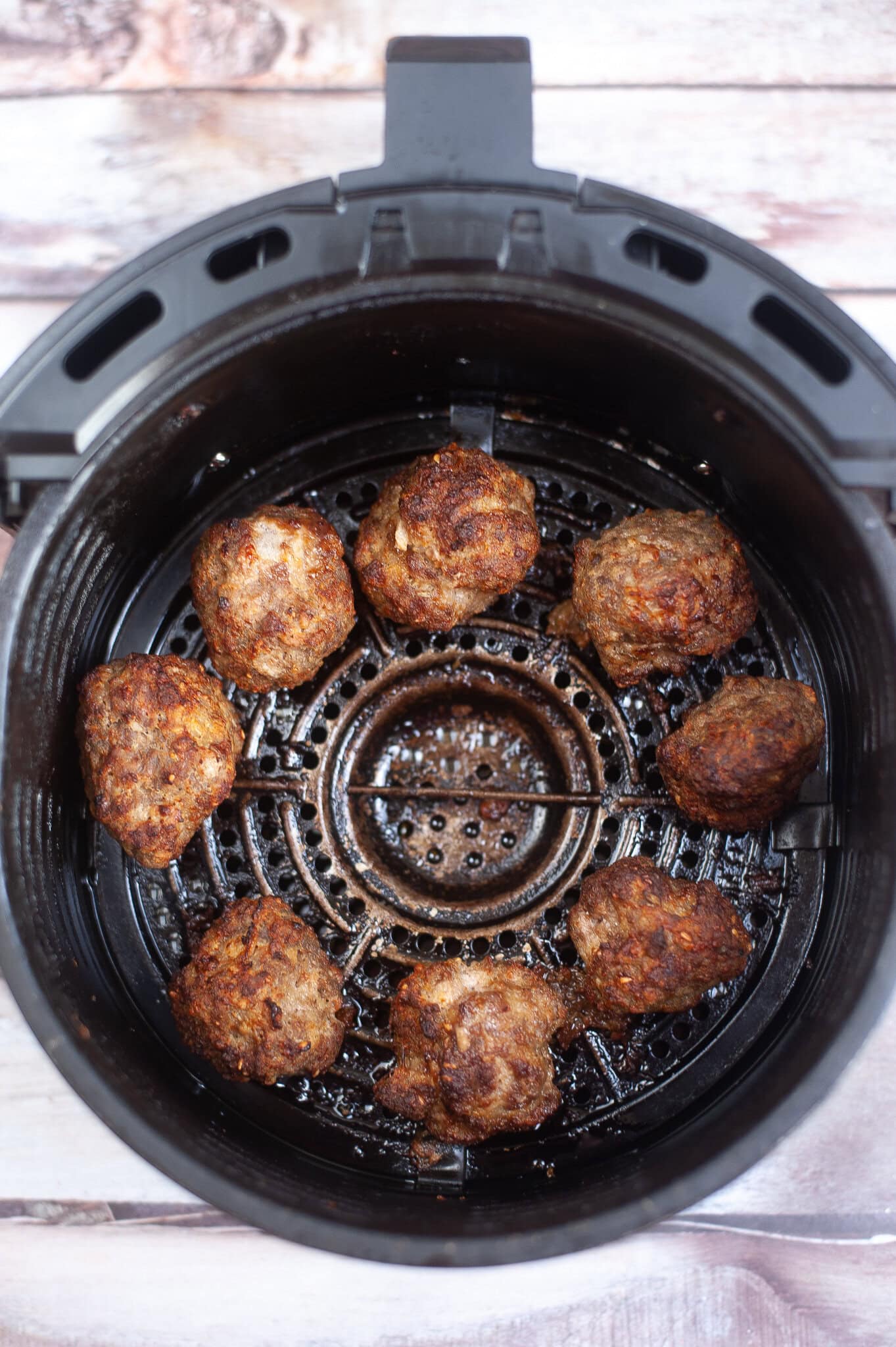Air fryer meatballs inside the air fryer cooling