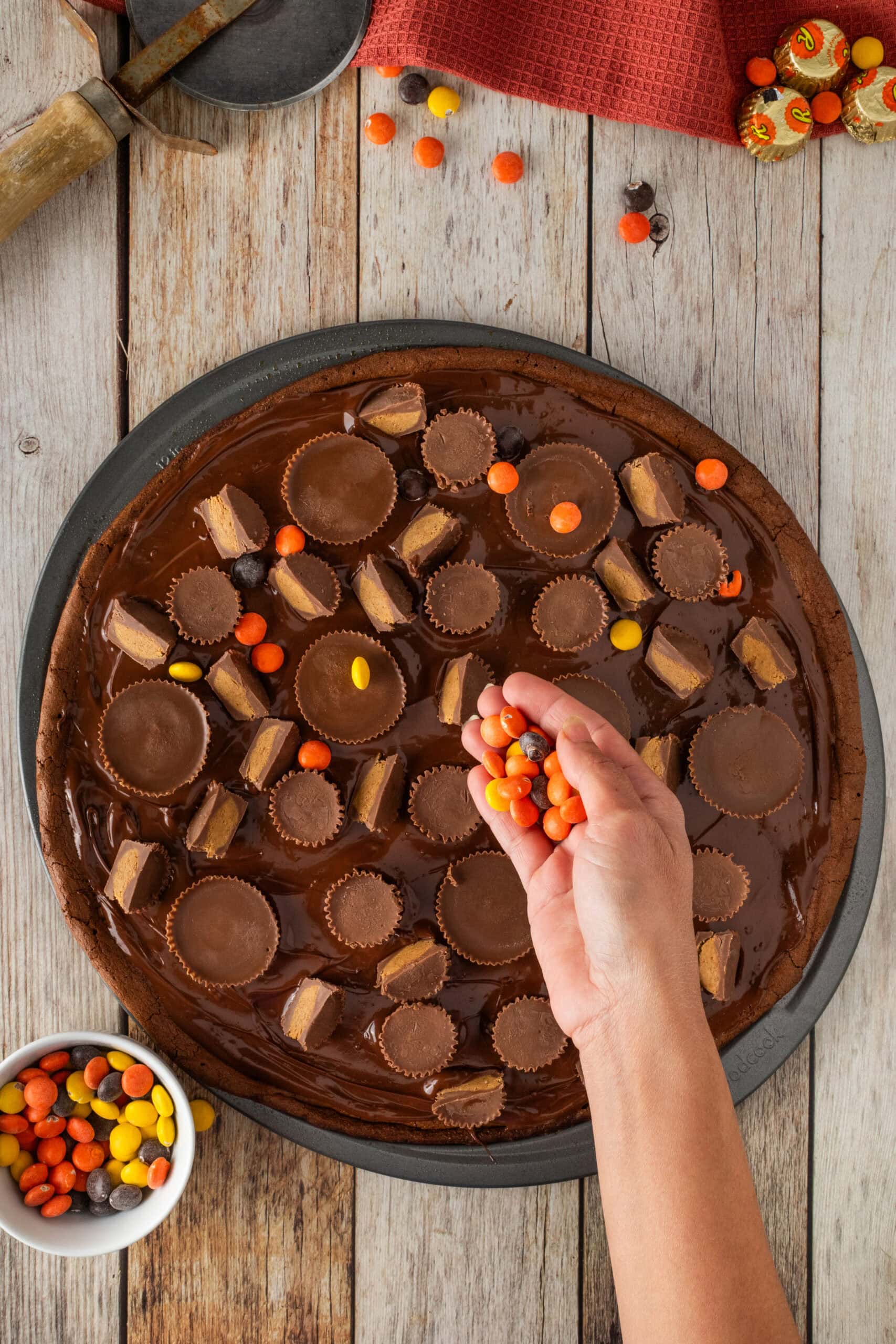 While the ganache is settling on top, adding Reese's pieces and cups being placed on top