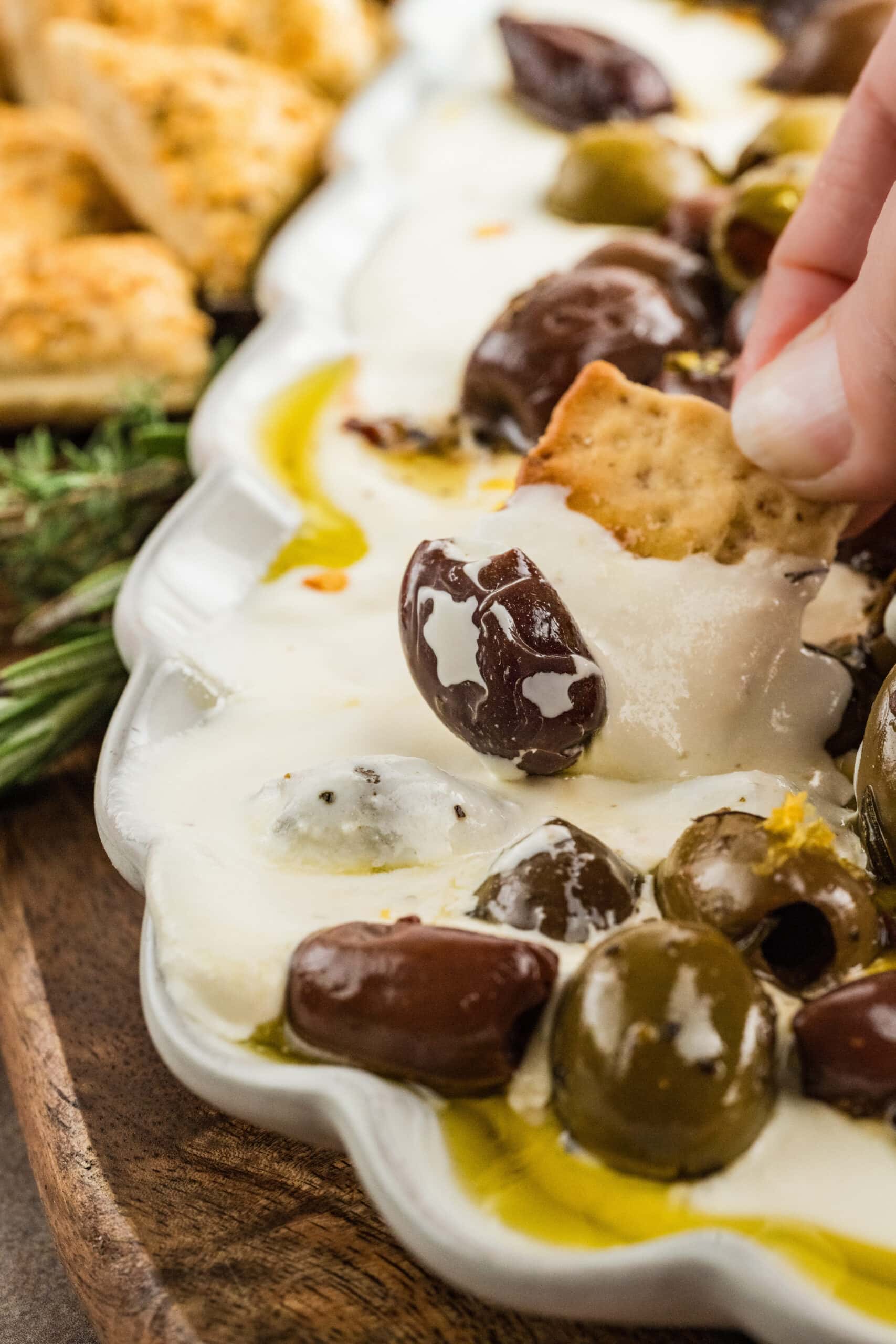 Cracker is being dipped into whipped feta dip.