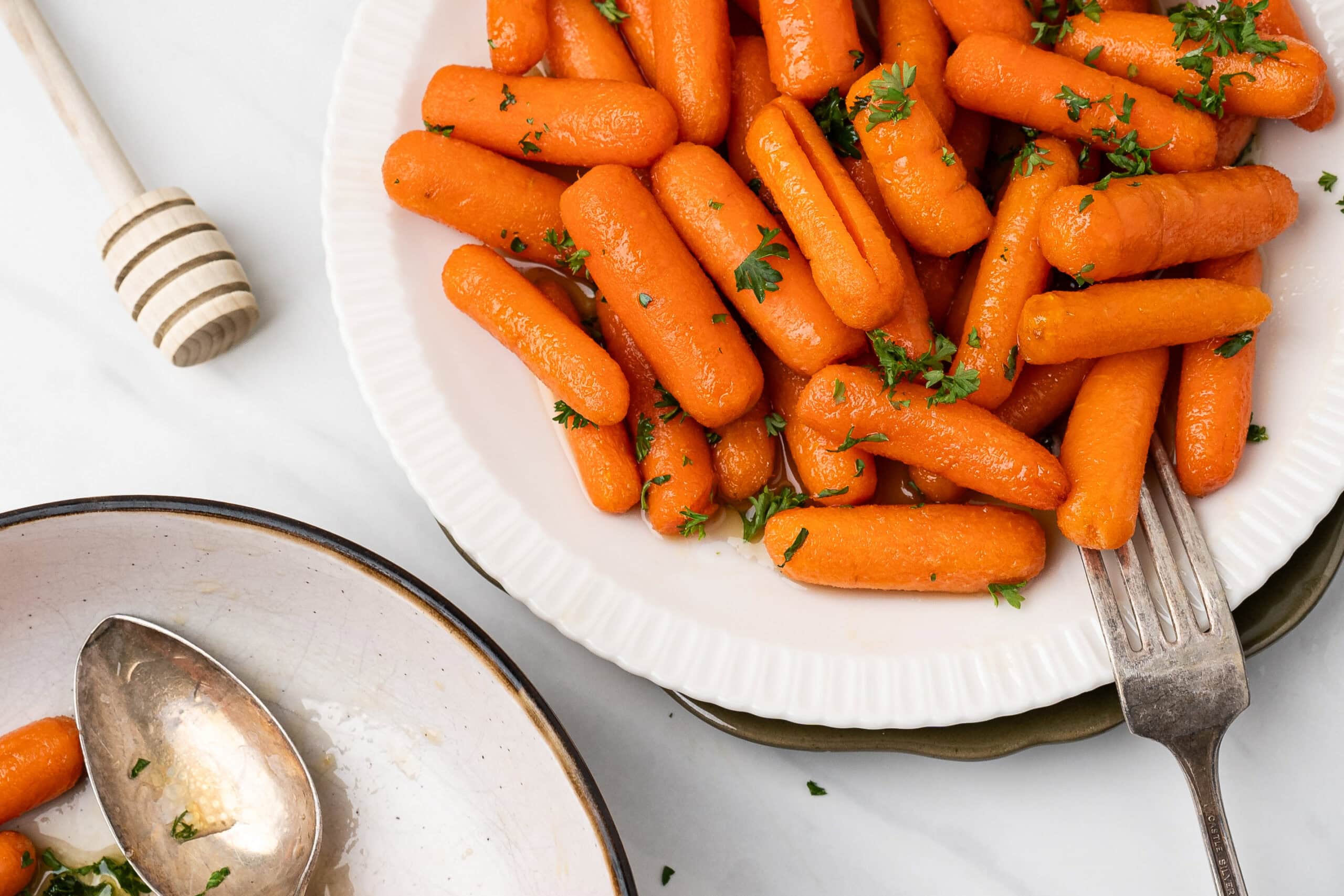 Air fryer baby carrots on a plate with a fork, ready to be enjoyed