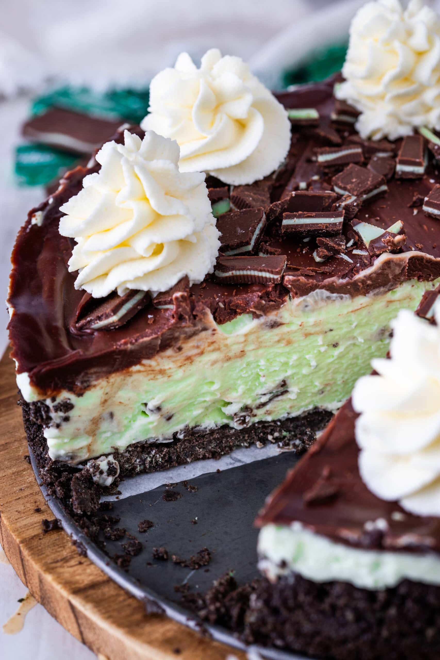 Close up side view of the whole cheesecake with a slice taking out of it.