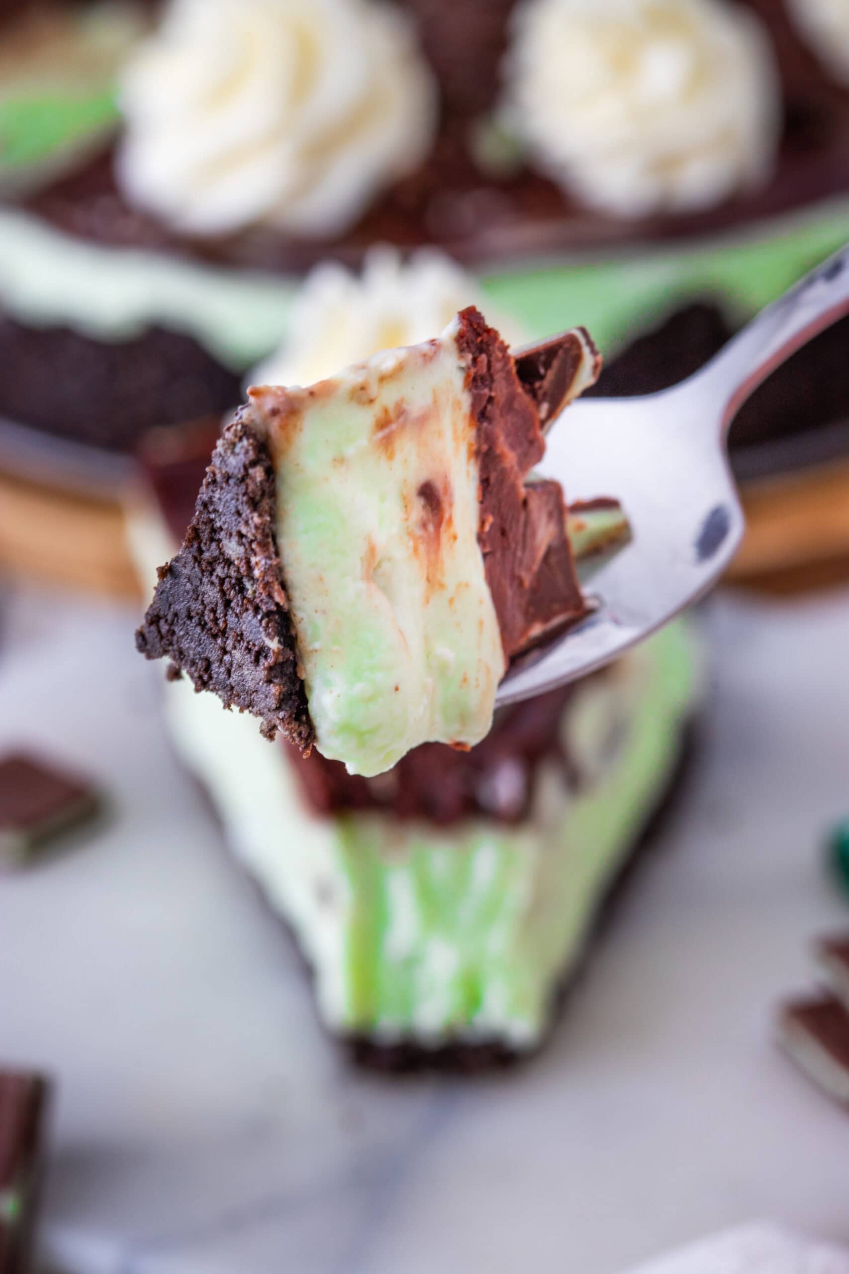 A close up of a fork holding a piece of the andes cheesecake