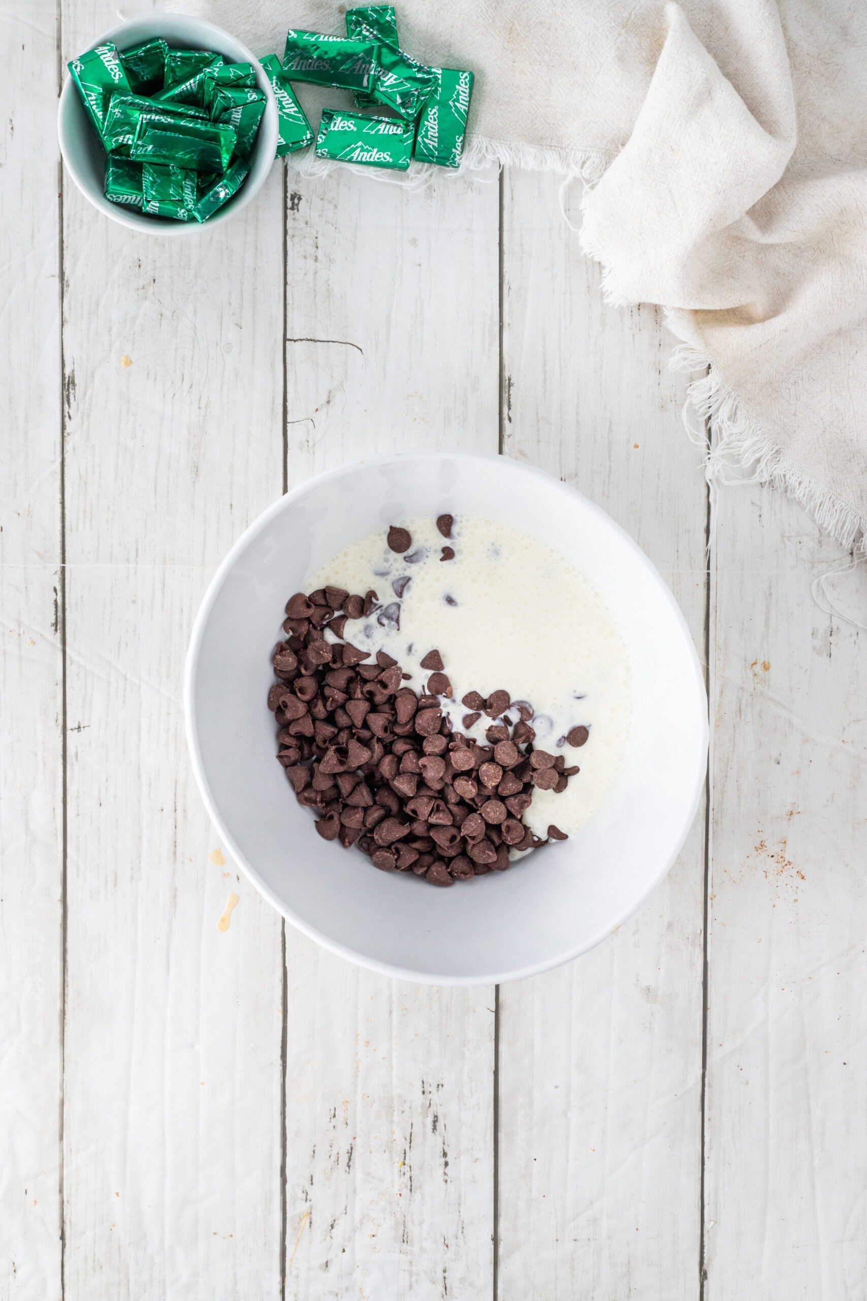 Creating the ganache with chocolate chips and heavy cream in a bowl
