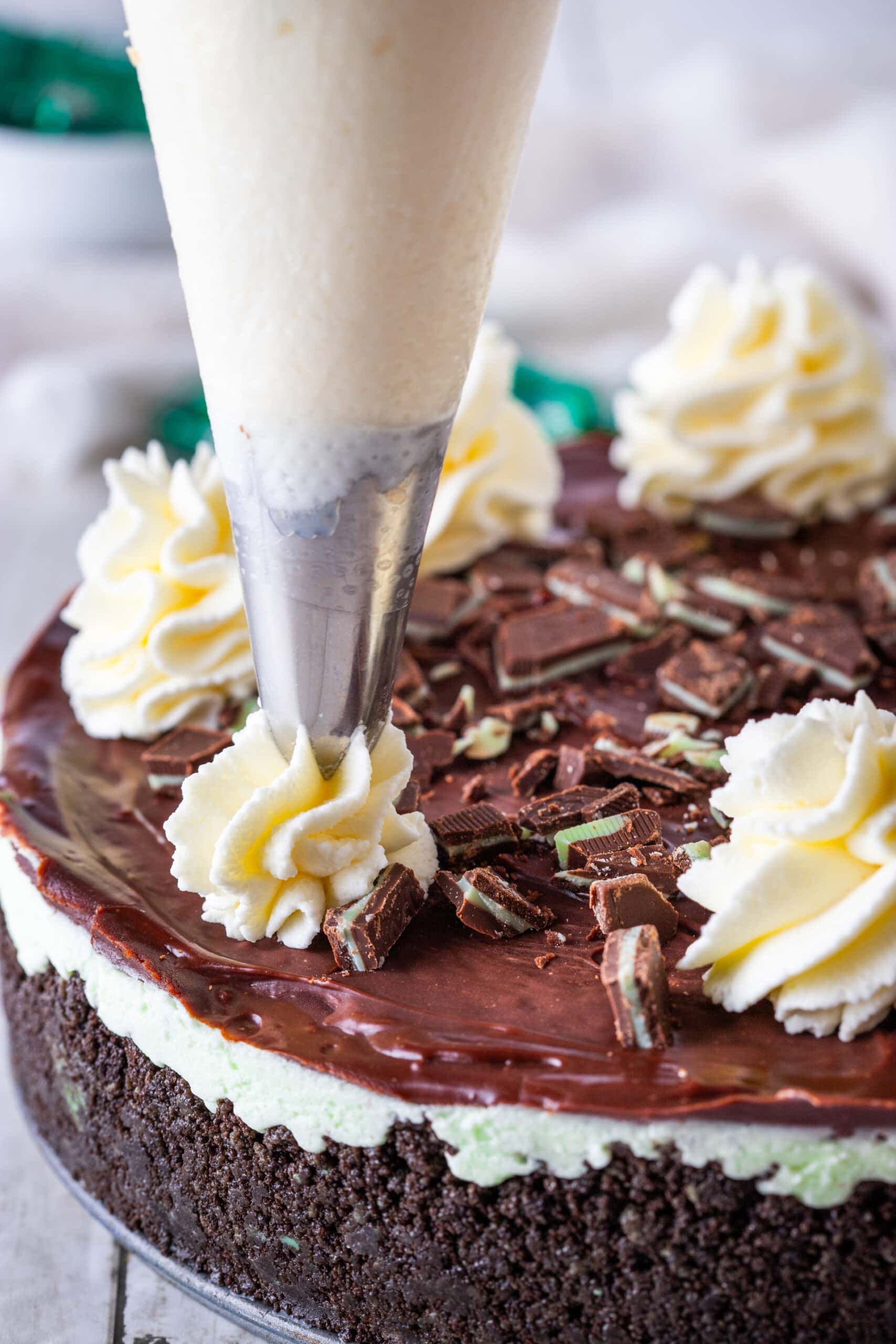 Piping the whip cream onto the cheesecake for the final process