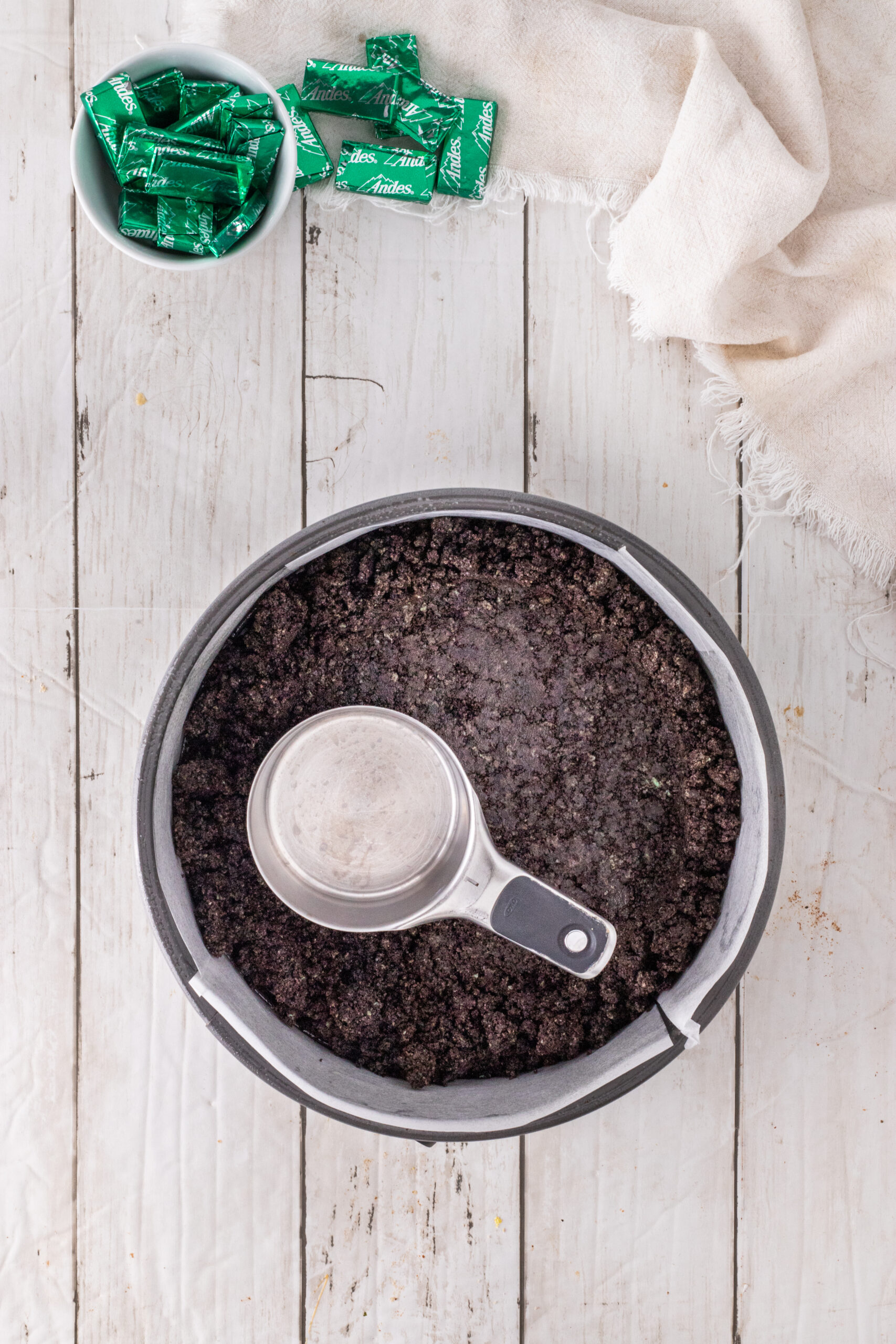 Pressing down the crushed oreo cookies down in the springform pan