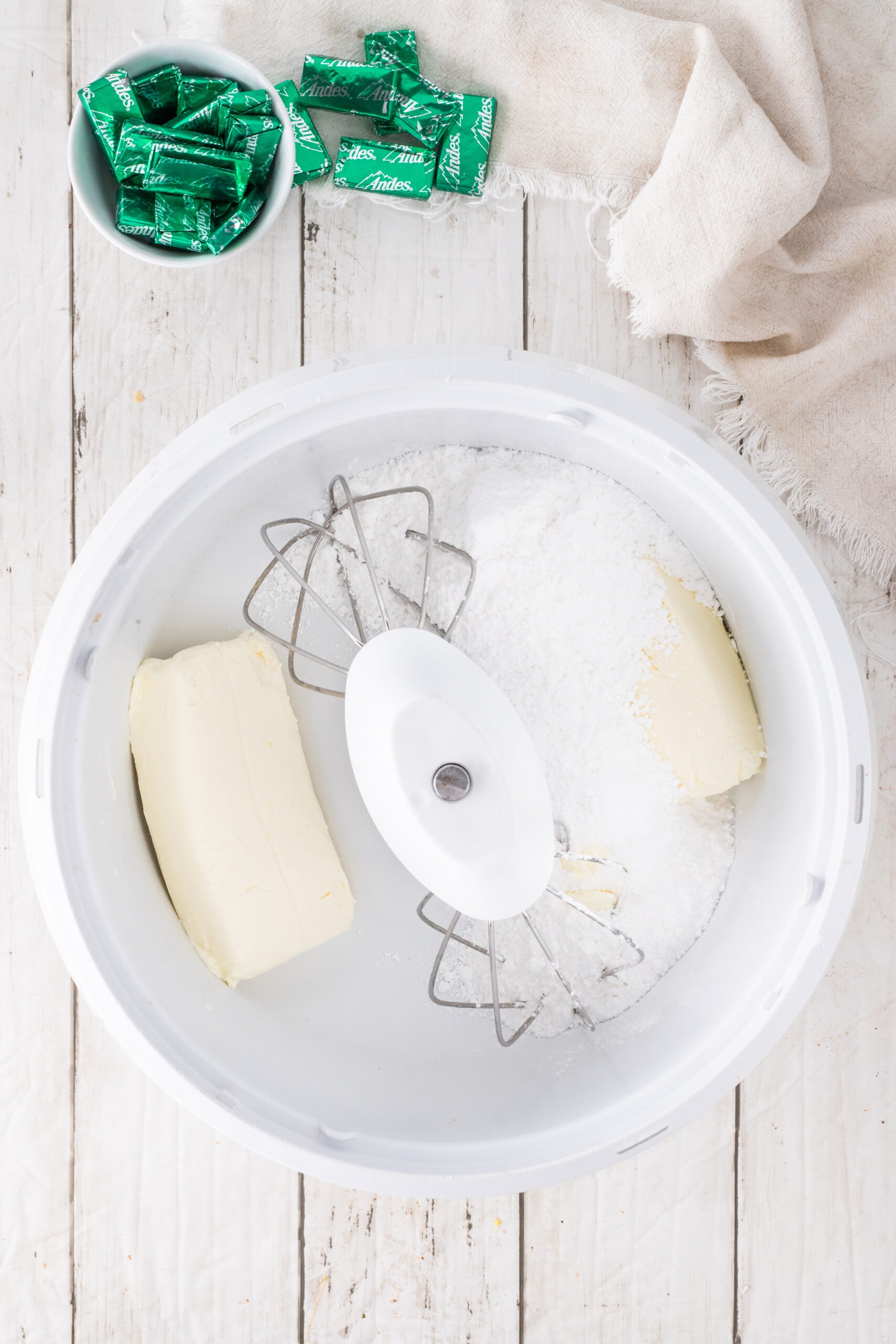Powdered sugar and softened cream cheese in mixing bowl