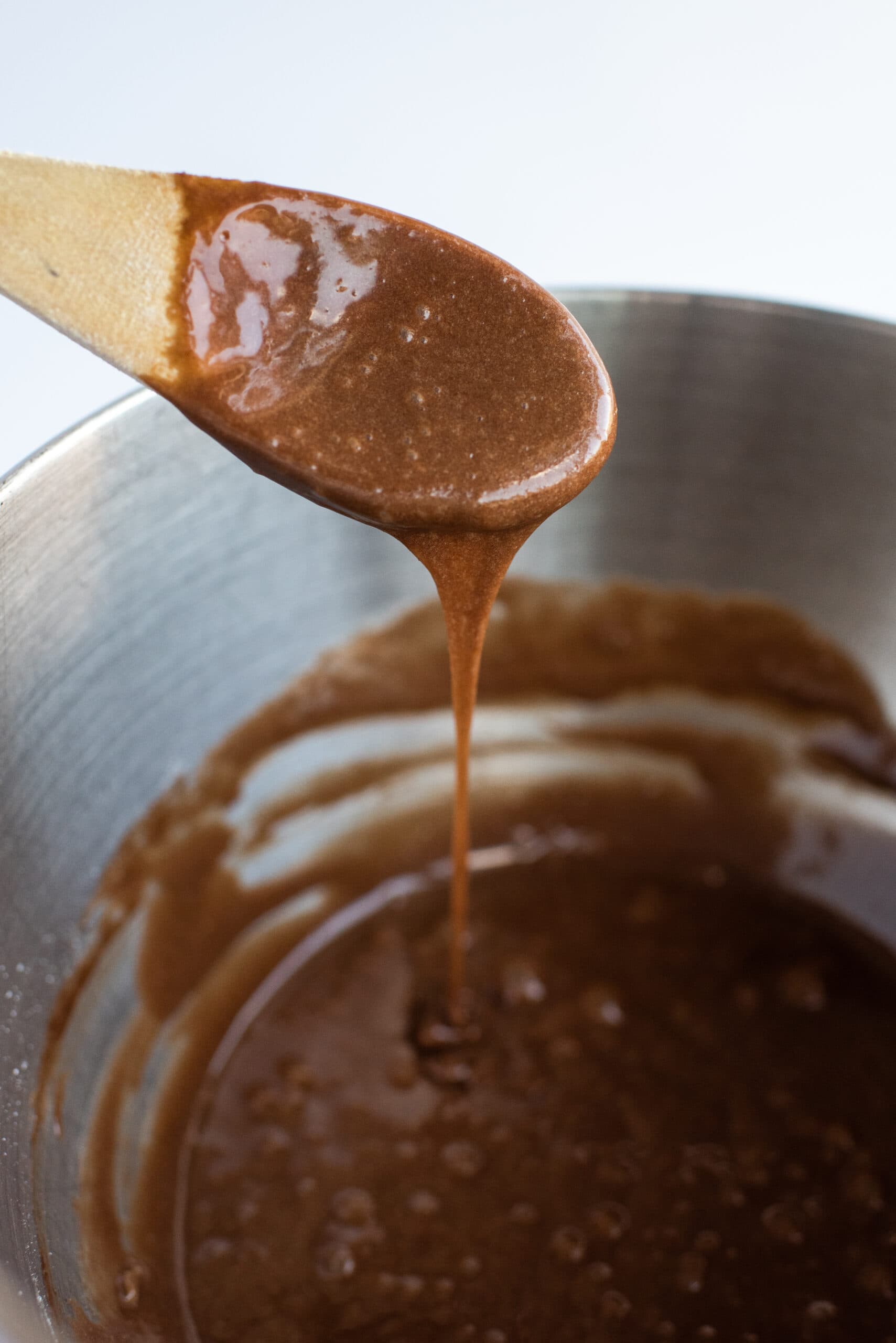 Brownie batter being mixed with a wooden spoon