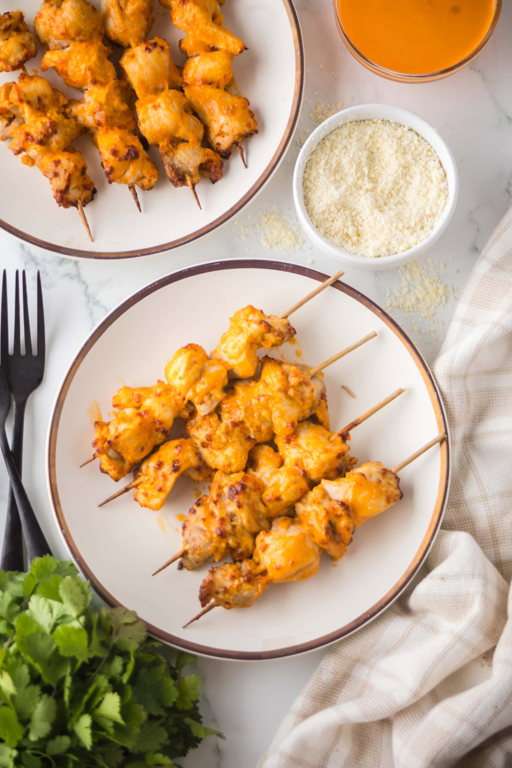 Buffalo chicken thighs are all plated on two plates and ready to be enjoyed