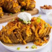 buffalo chicken stuffed potatoes topped with crumbled bacon, green onions, and sour cream