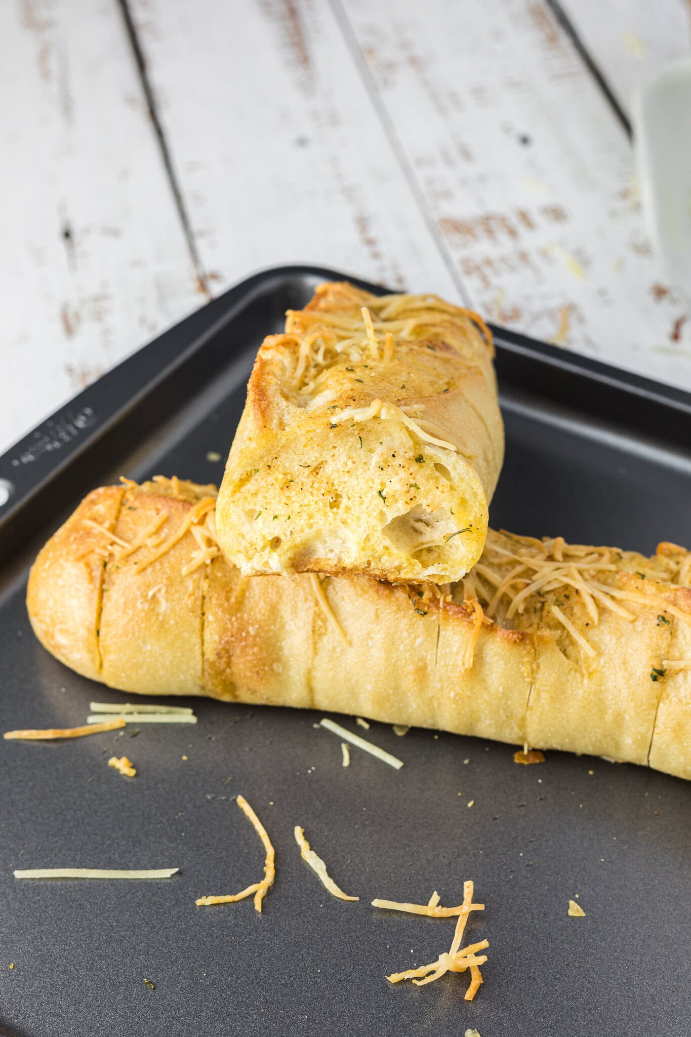 Cheesy garlic bread on a baking sheet, cut into slices.