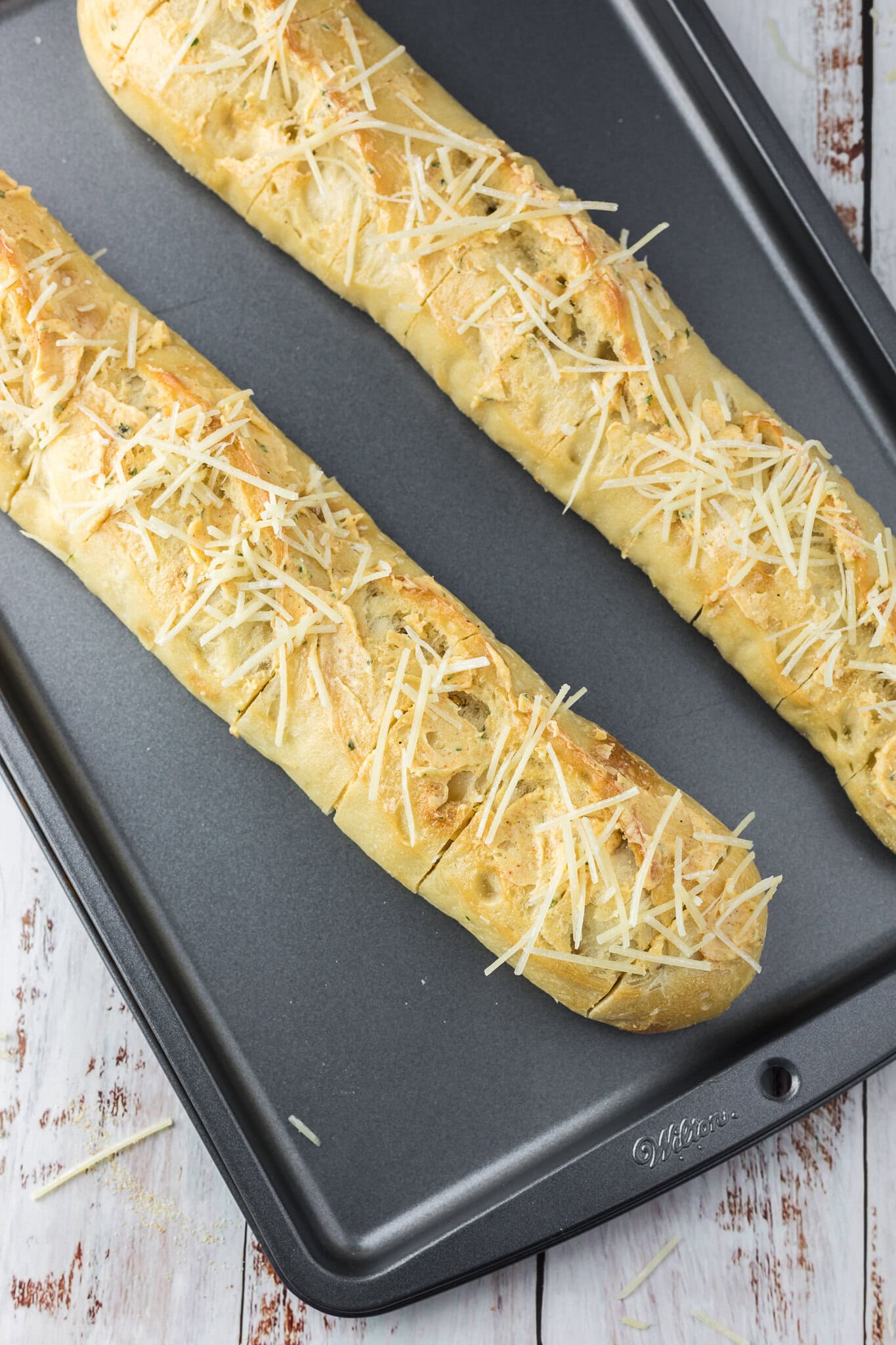 Cheesy garlic bread on a baking sheet, cut in slices