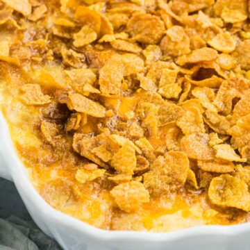 Close up cheesy potatoes in a baking dish, all baked and gooey