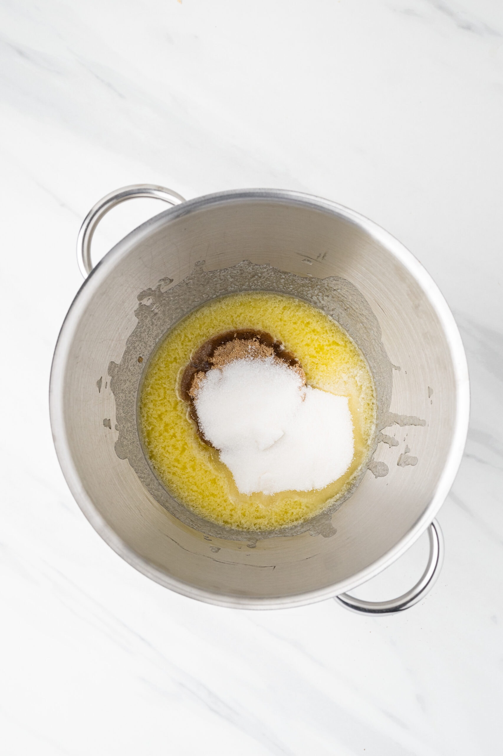 Melted butter in a mixing bowl with white and brown sugars