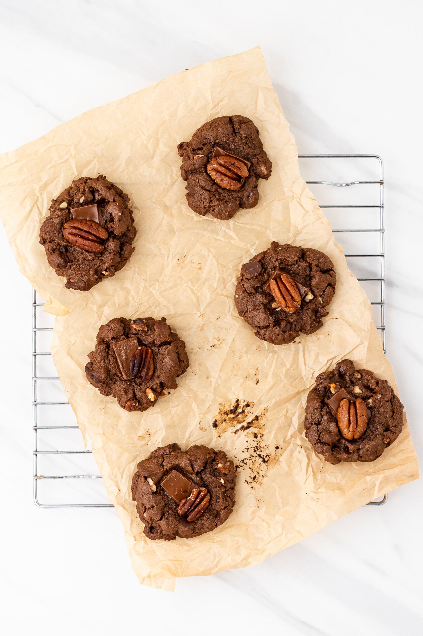 Chewy double chocolate pecan cookies cooling on a wire rack