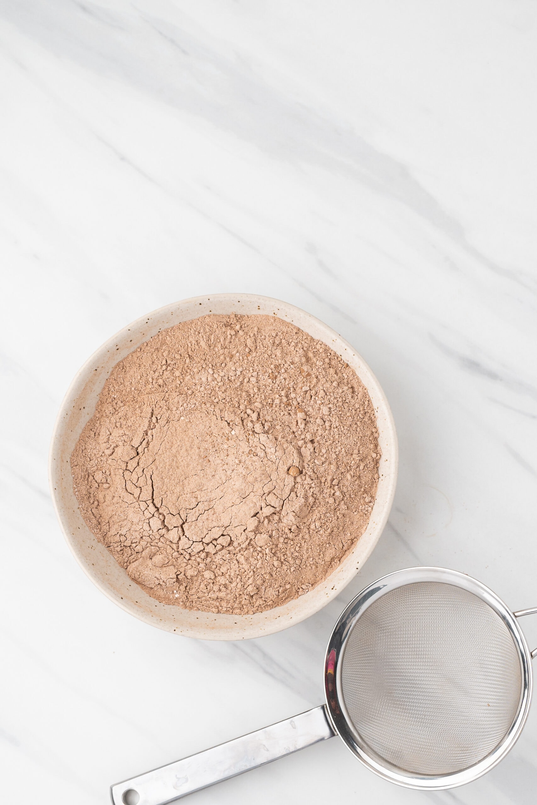 Sifting the cocoa powder, flour, salt, and baking soda