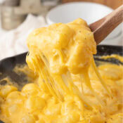 a scoop of gnocchi mac and cheese with melty cheese hanging down