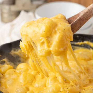 a scoop of gnocchi mac and cheese with melty cheese hanging down