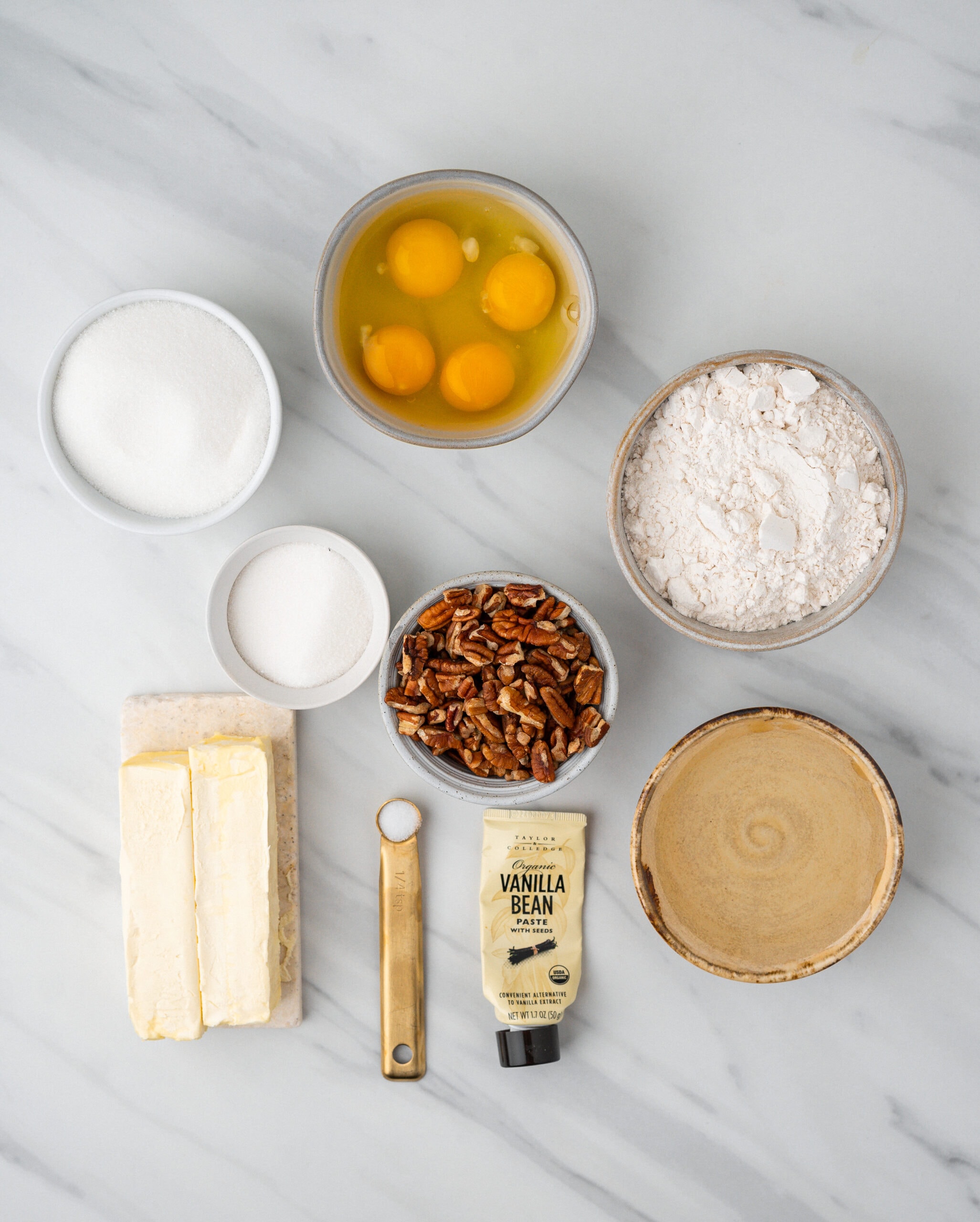 All ingredients to make easy pecan pie bars: butter, vanilla bean paste, pecans, flour, sugar salt, eggs, corn syrup