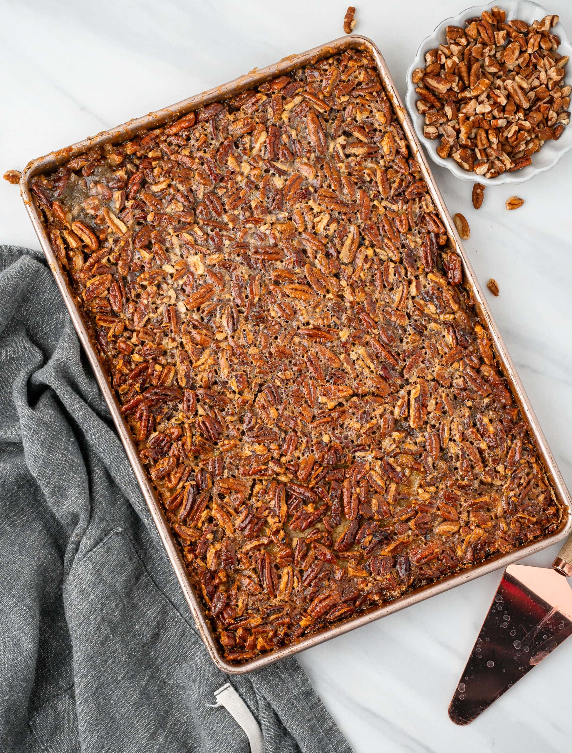 Pecan pie bars are cooling on a baking sheet