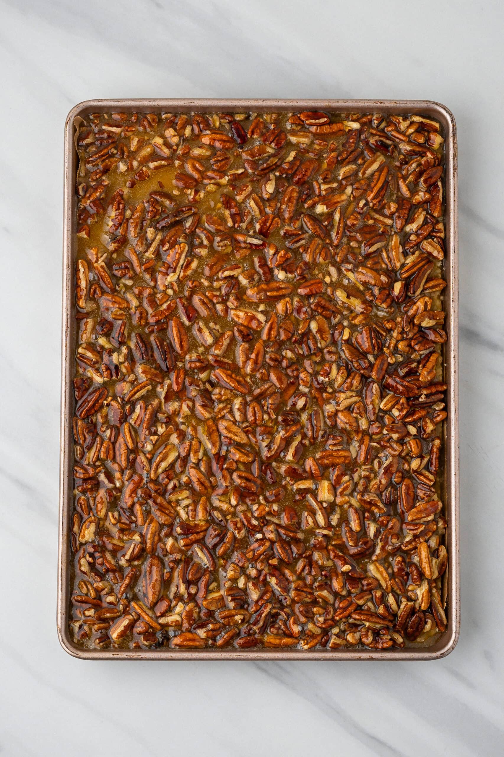 Corn syrup, eggs, sugar, melted butter, vanilla and pecans on poured into a baking sheet pan