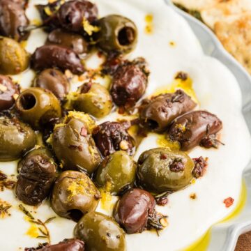 Whipped Feta dip with olives on a white platter