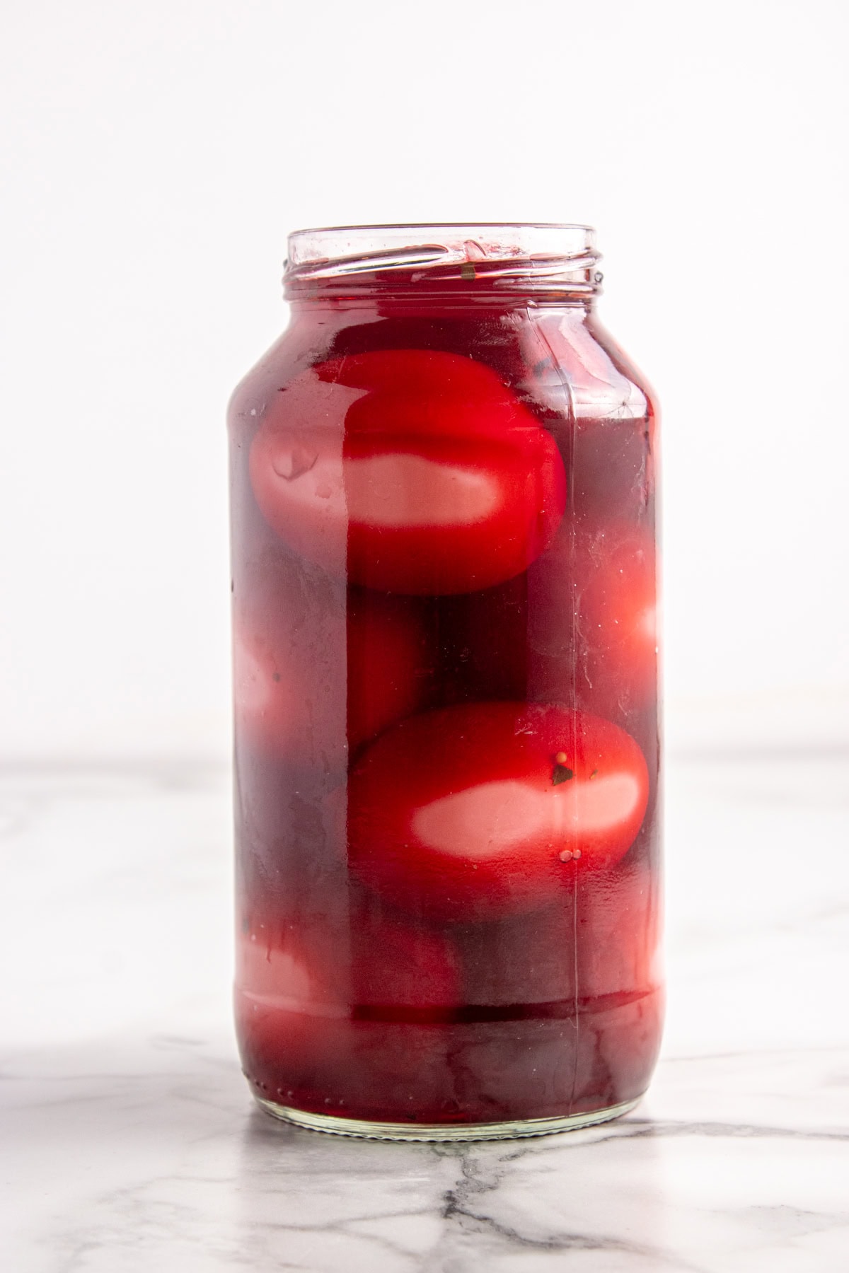 Warm brine is covering the eggs in a sterilized jar