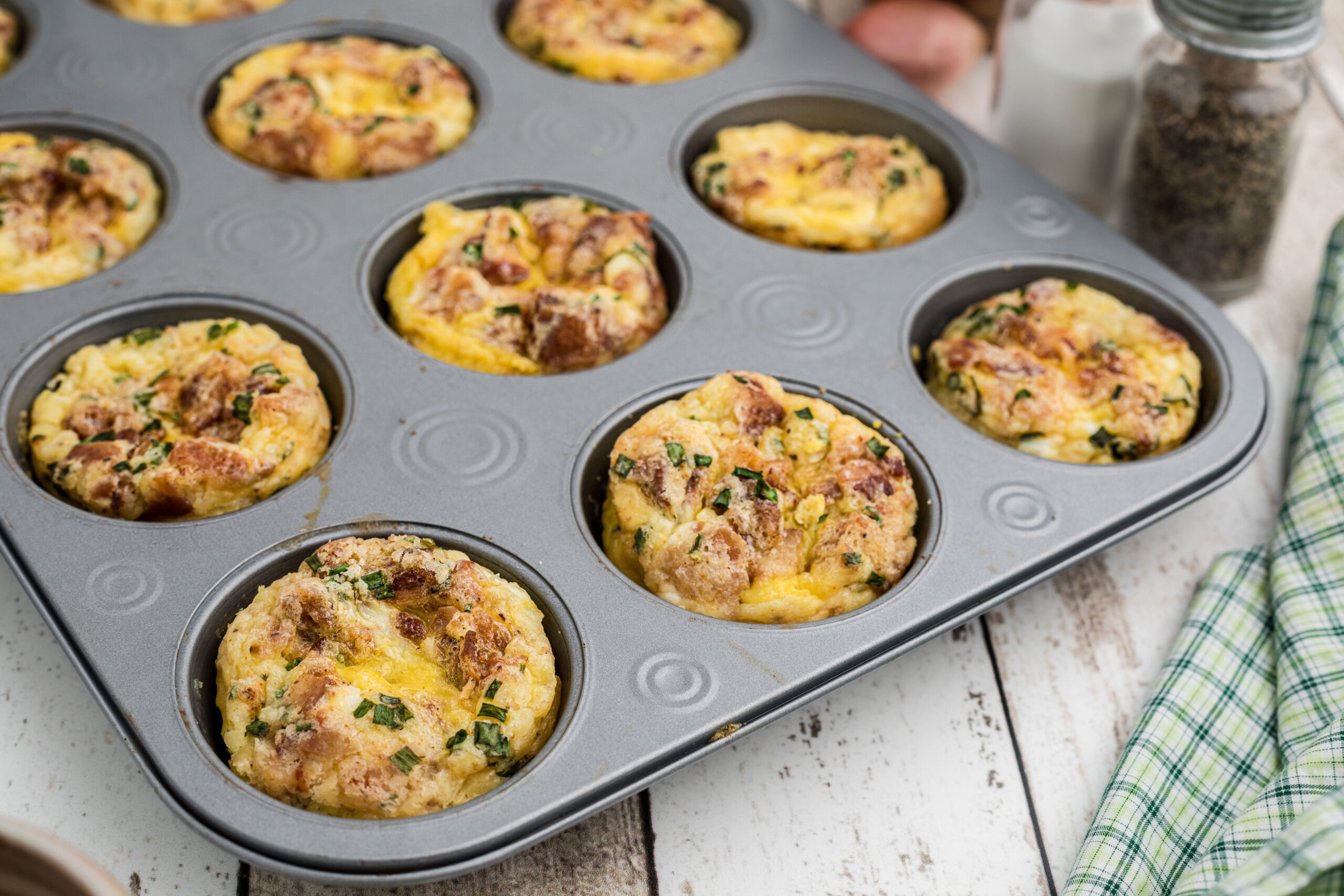 Breakfast muffins baked in a muffin tin, being cooled