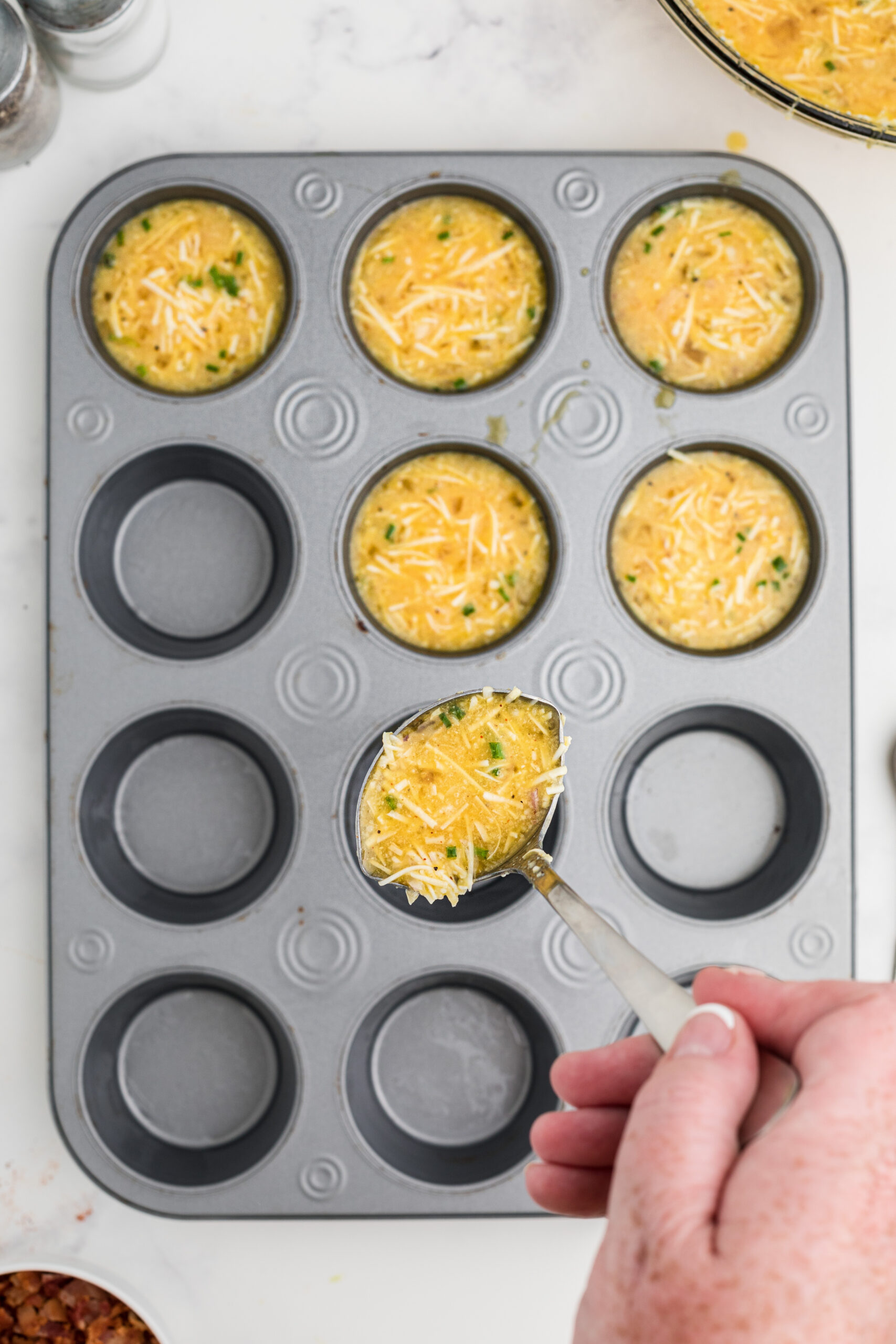 Pouring the egg mixture into the muffin tin