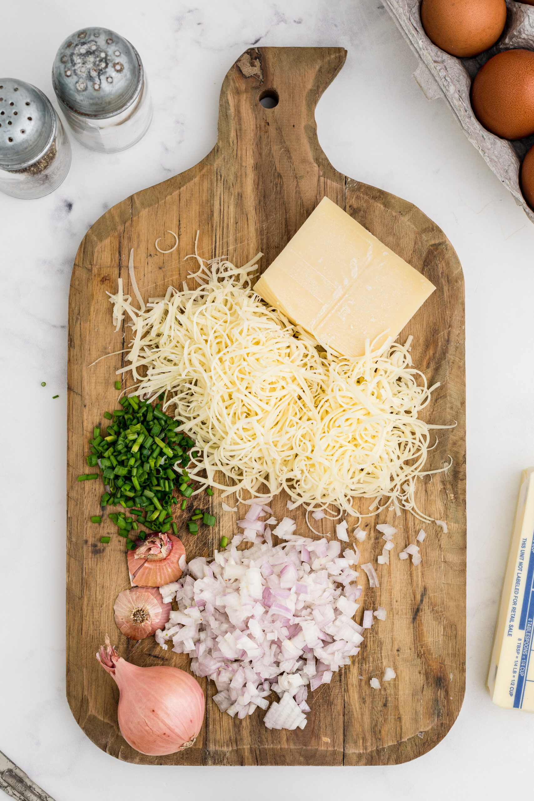 Chopping the shallots, chives and shredding the Gruyere cheese on a wooden cutting board