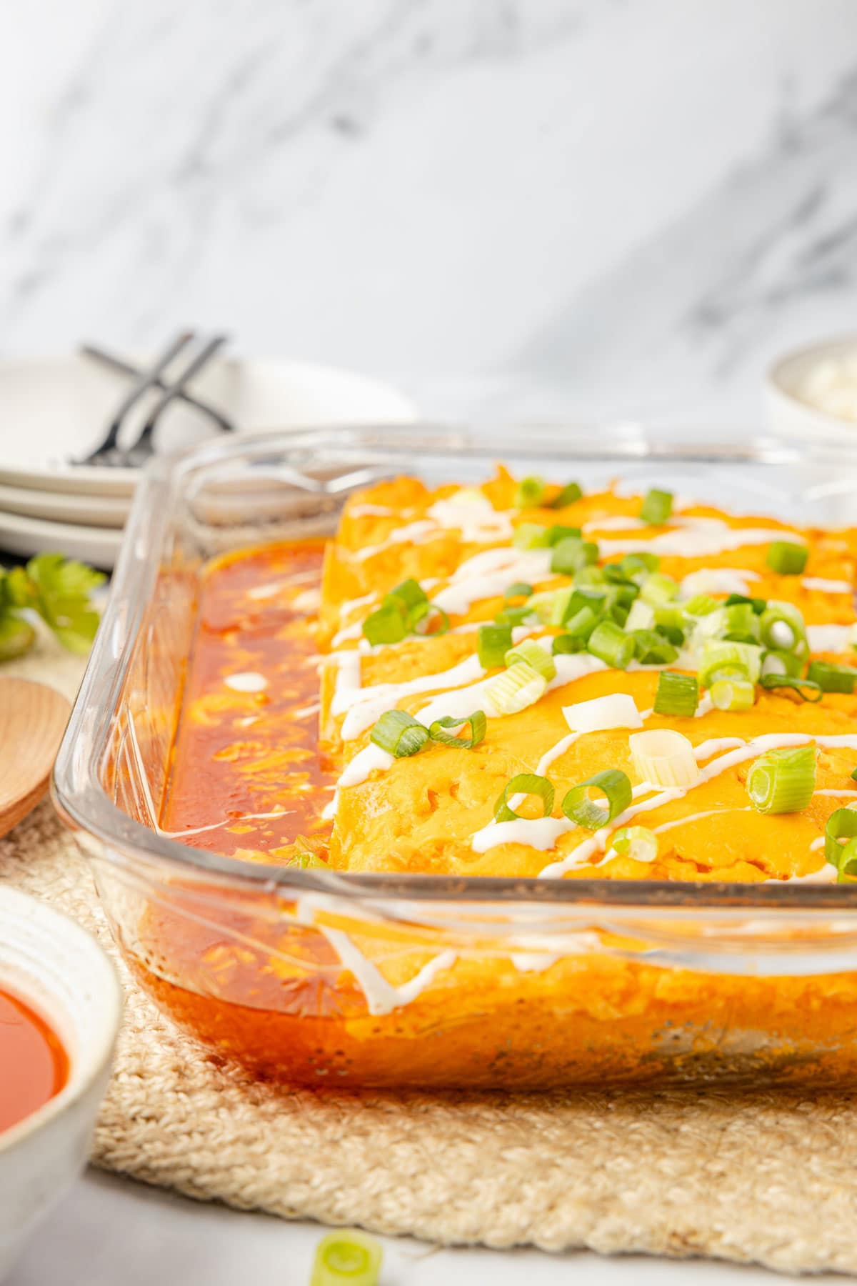 Side view of buffalo chicken enchiladas all baked in pan