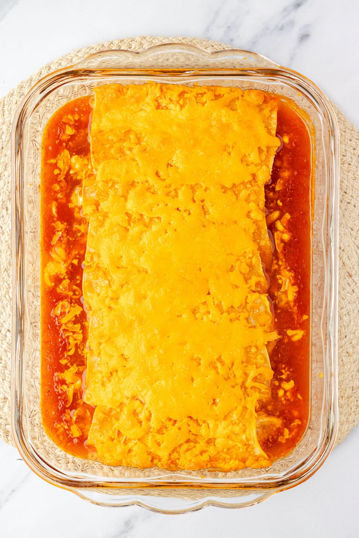 Buffalo chicken enchiladas all baked and ready to be cooled, topped with garnishes