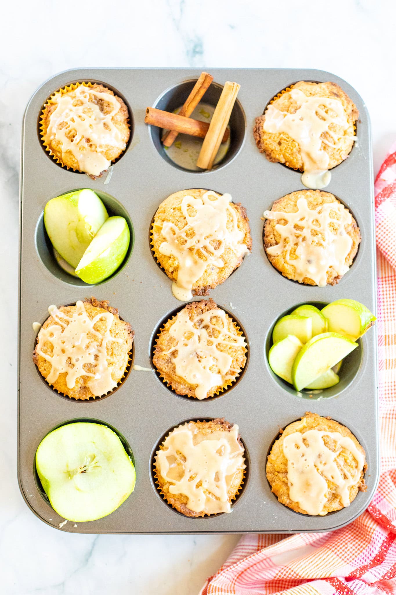Caramel muffins in a muffin tin, drizzled with caramel drizzle, all baked, ready to be served