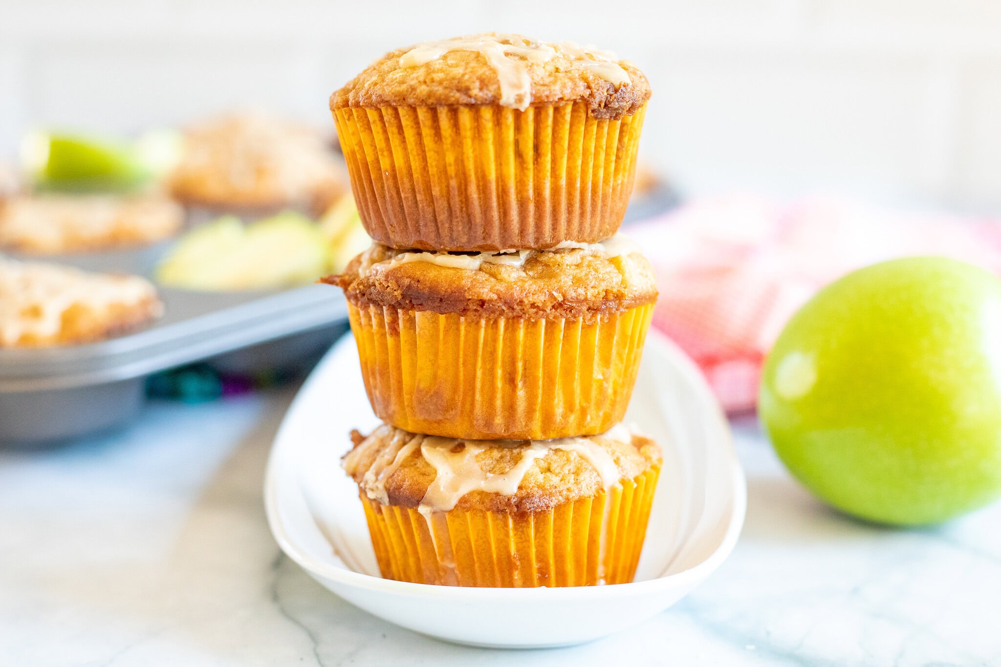 Stack of three caramel apple muffins with caramel drizzle