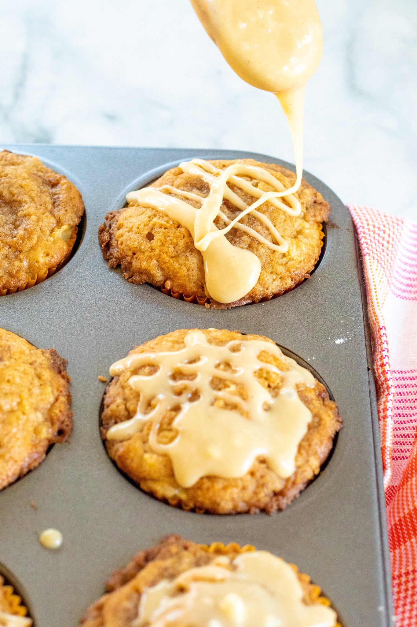 Adding the caramel glaze to the tops of the muffins