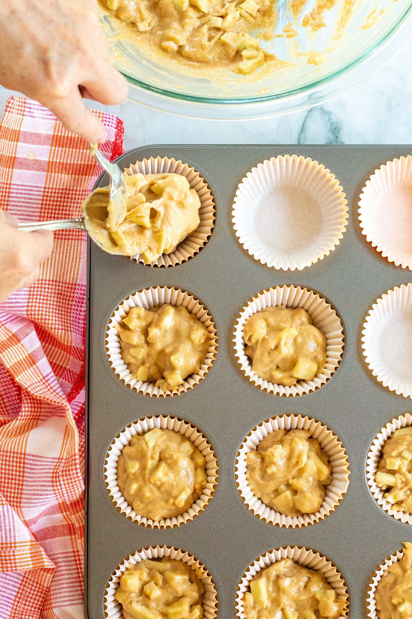Filling muffin cup liners with caramel apple batter mixture