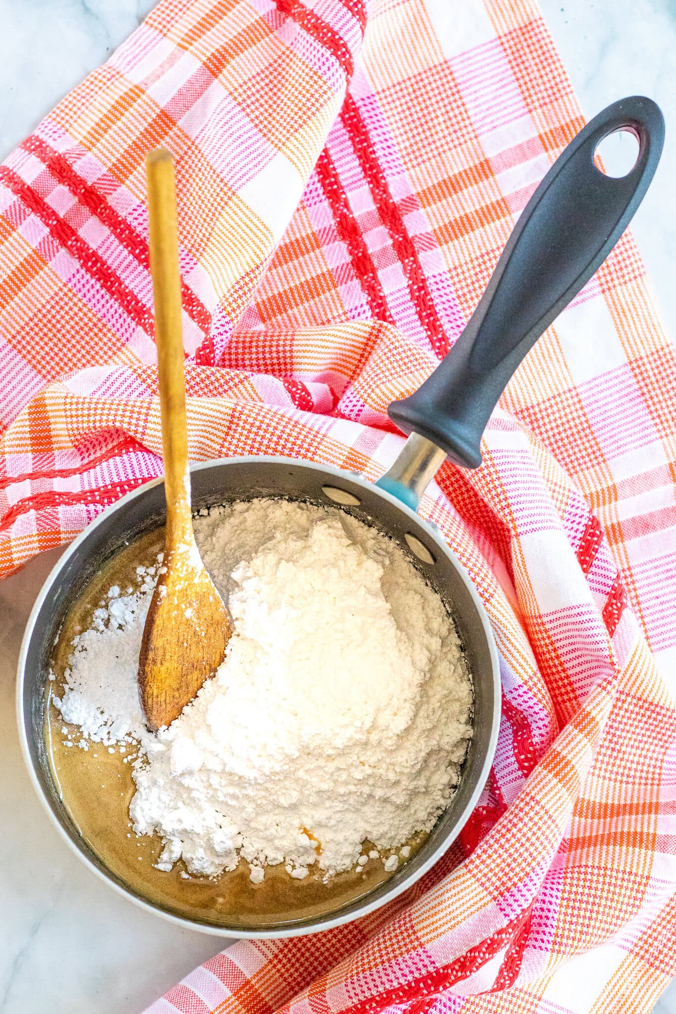 In a pan, making caramel glaze of brown sugar, powdered sugar, milk and butter