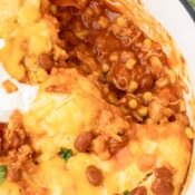 Close up of chicken chili with dumplings and topped with cheddar cheese