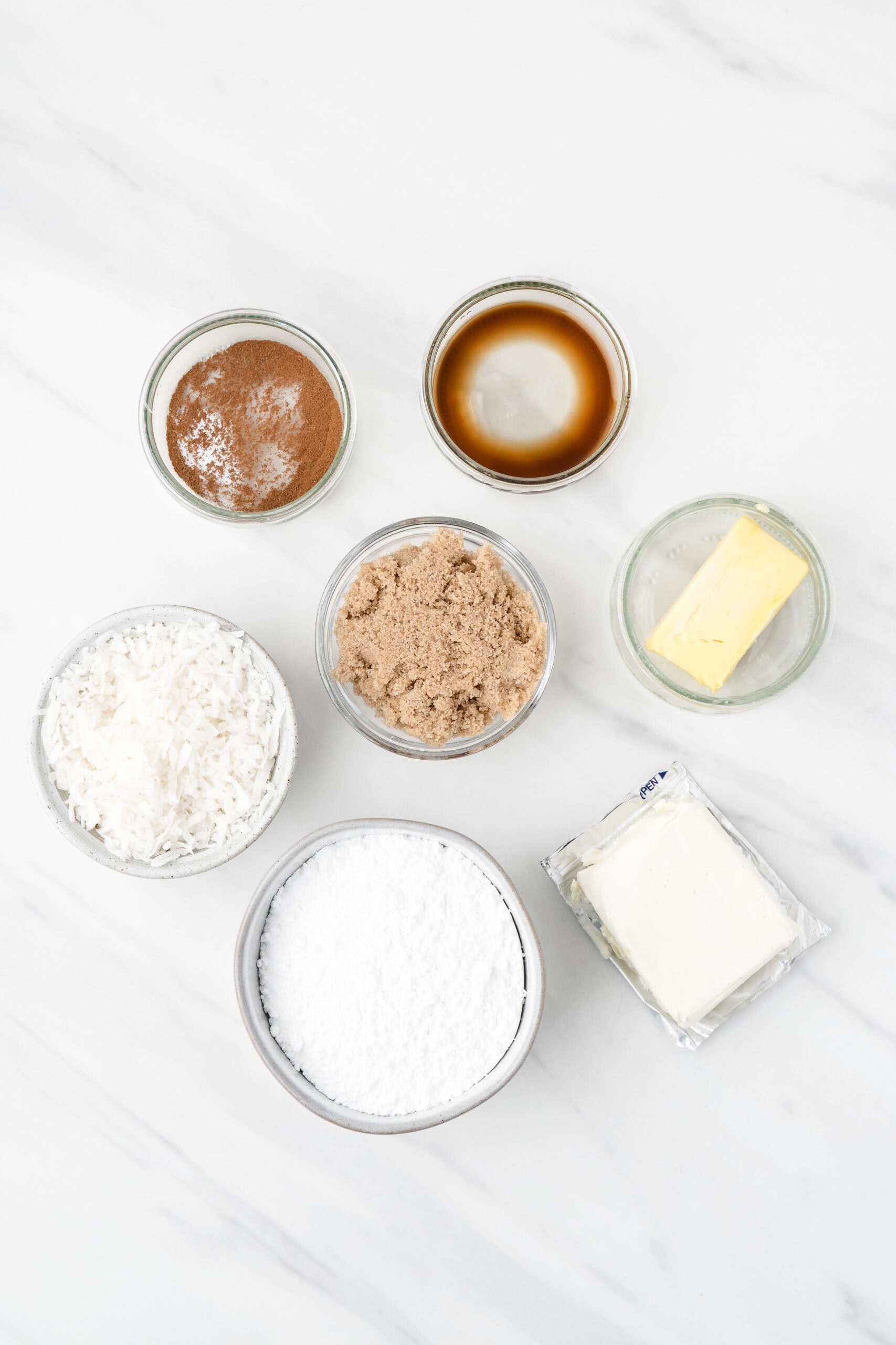 Ingredients for irish potato candy: powdered sugar, cream cheese, brown sugar, shredded coconut, brown sugar, butter, cinnamon, vaniila