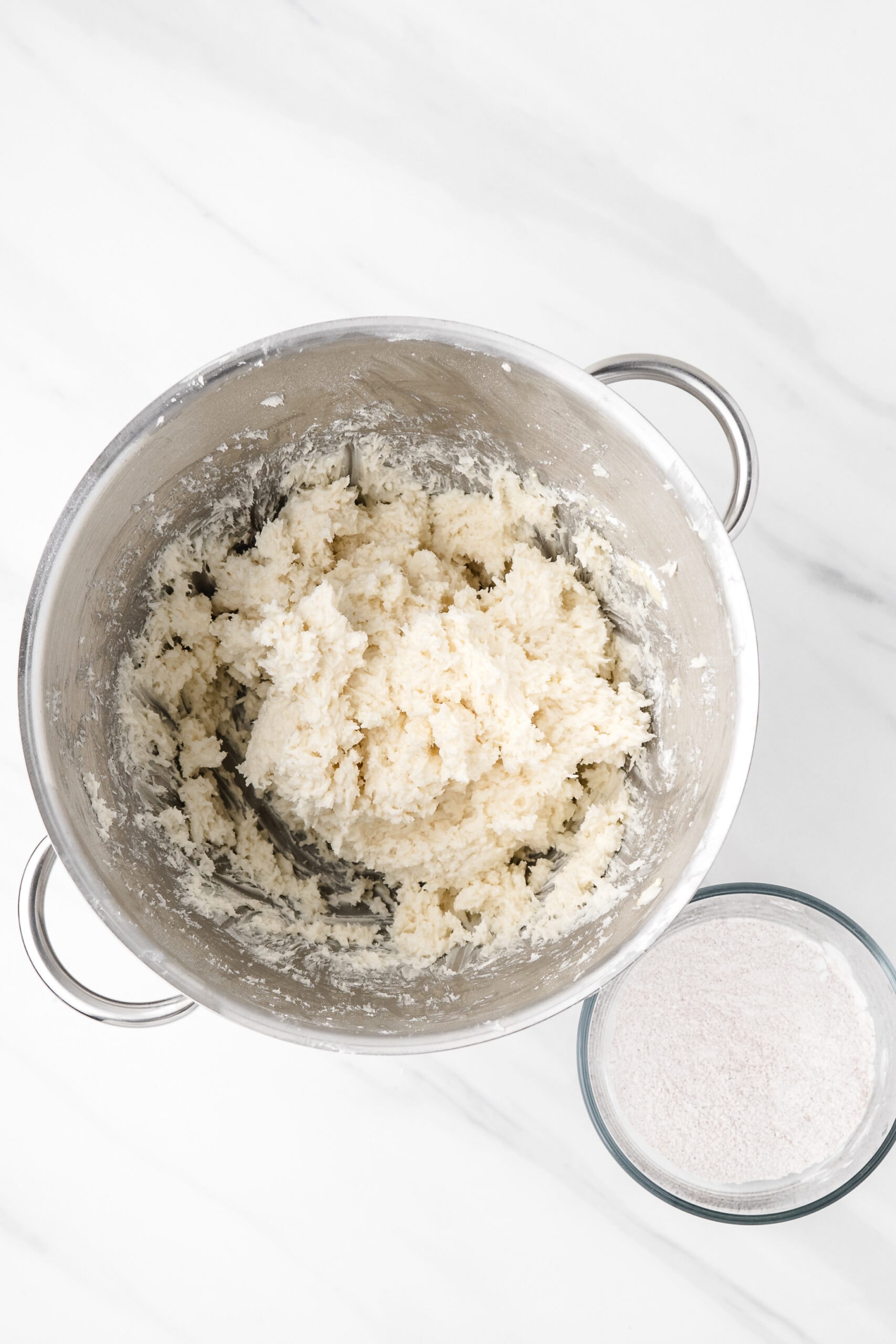Mixing bowl with shredded coconut, powdered sugar, cream cheese and vanilla all mixed together.
