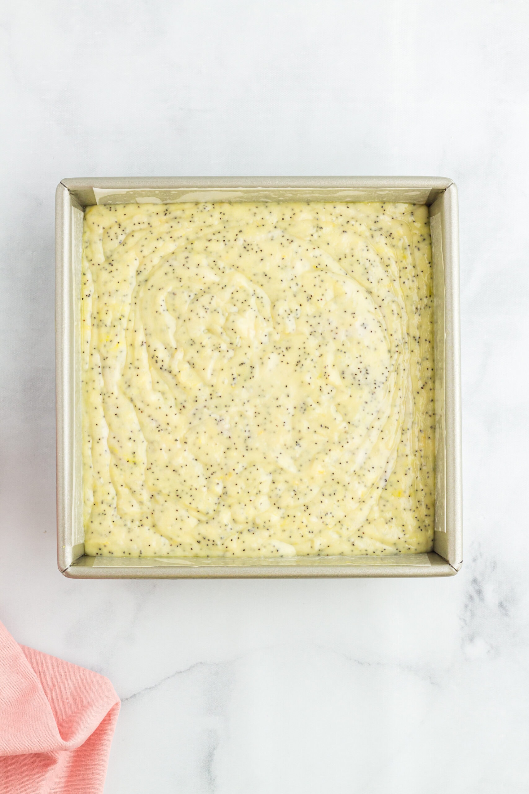 Lemon poppy seed batter in a baking dish, ready to be baked