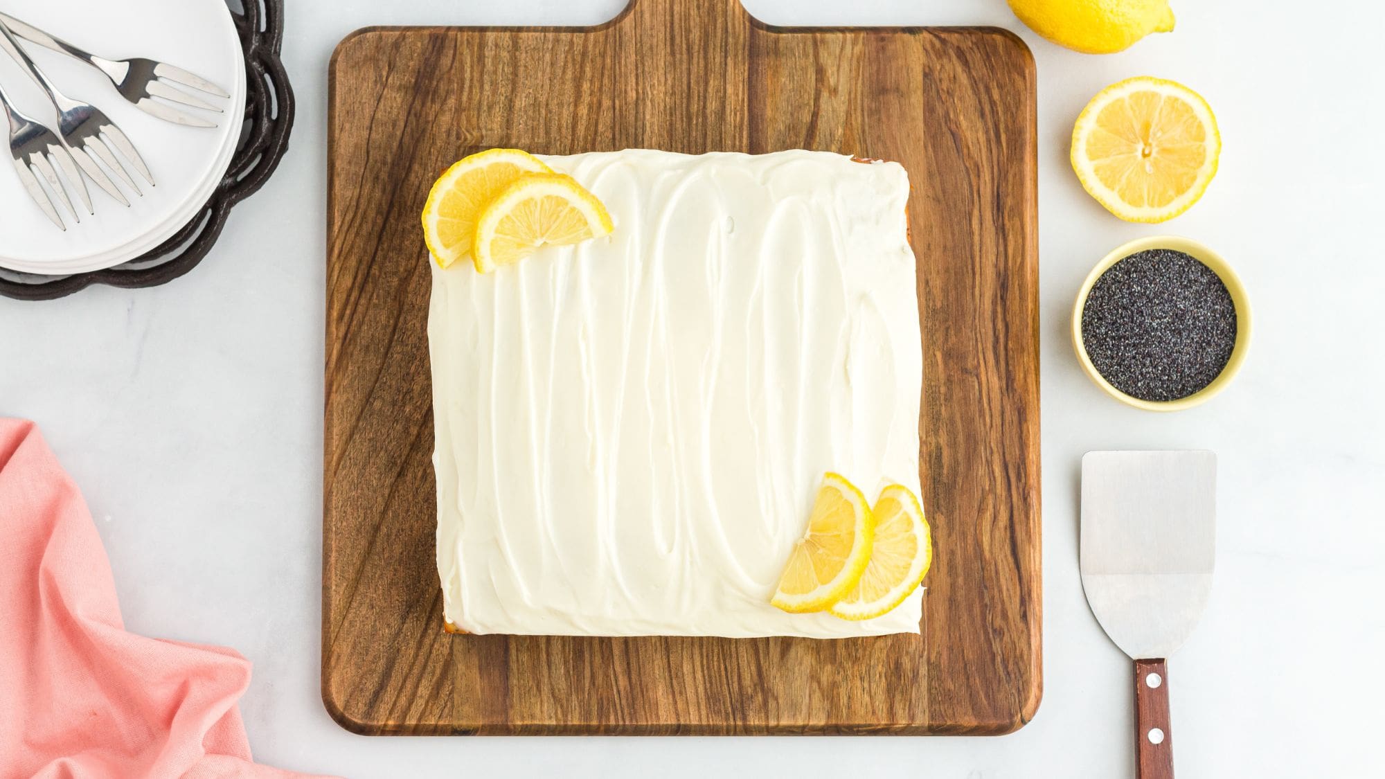 Lemon seed poppy cake on a wooden board ready to be cut and enjoyed