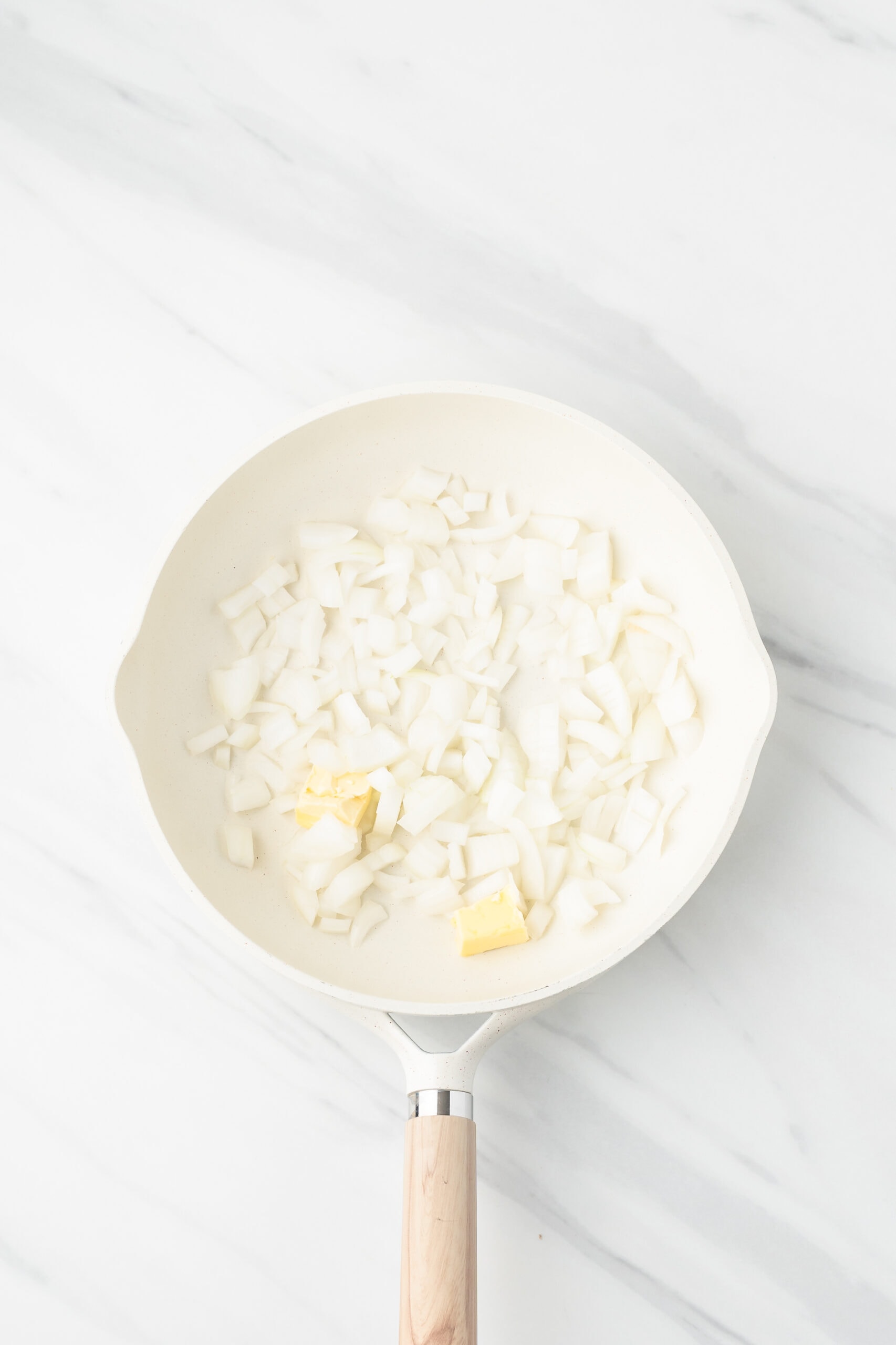 Diced onion in skillet, ready to be sauteed
