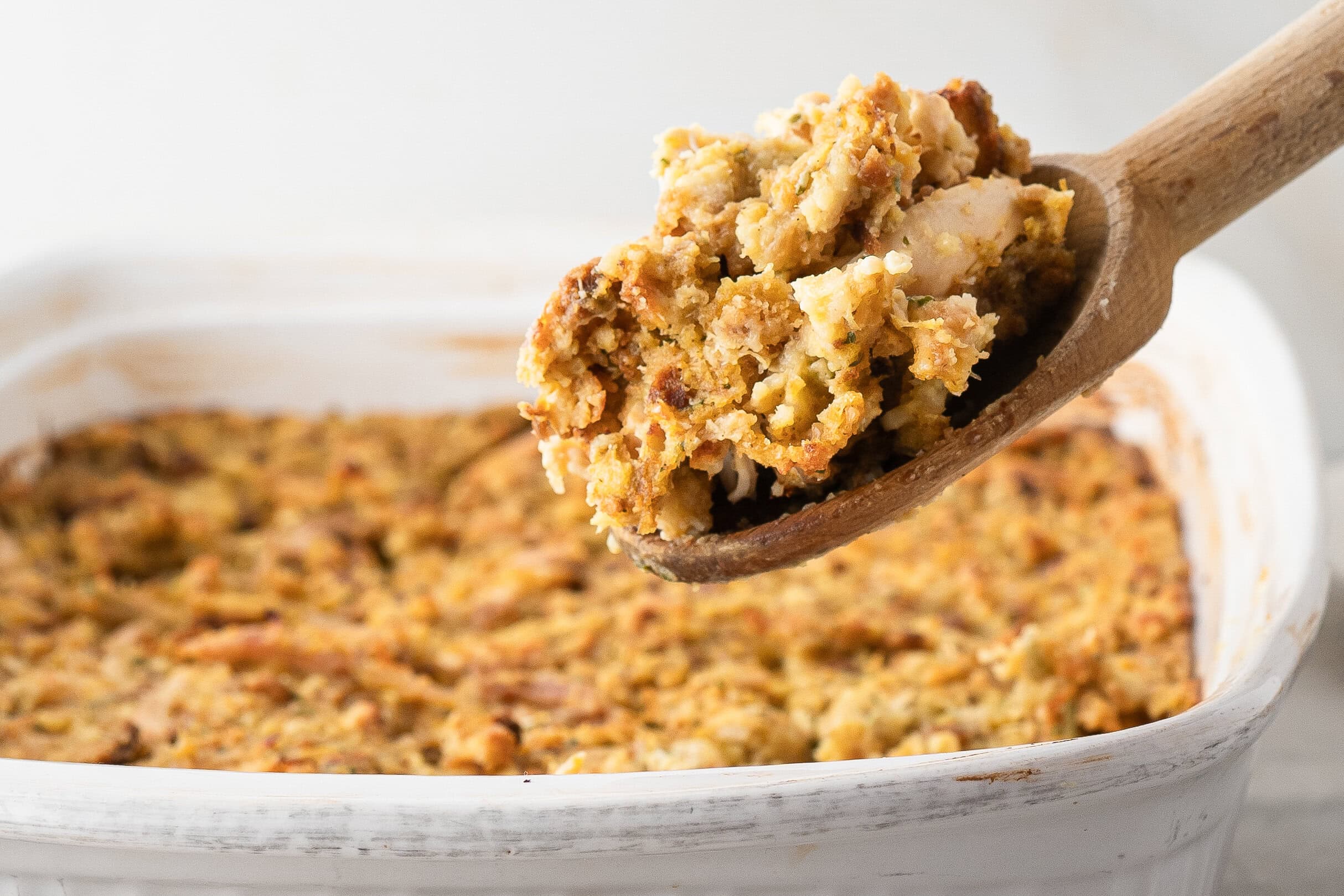 Stove top and rotisserie chicken casserole all baked and a spoon is holding up a scoop of the casserole