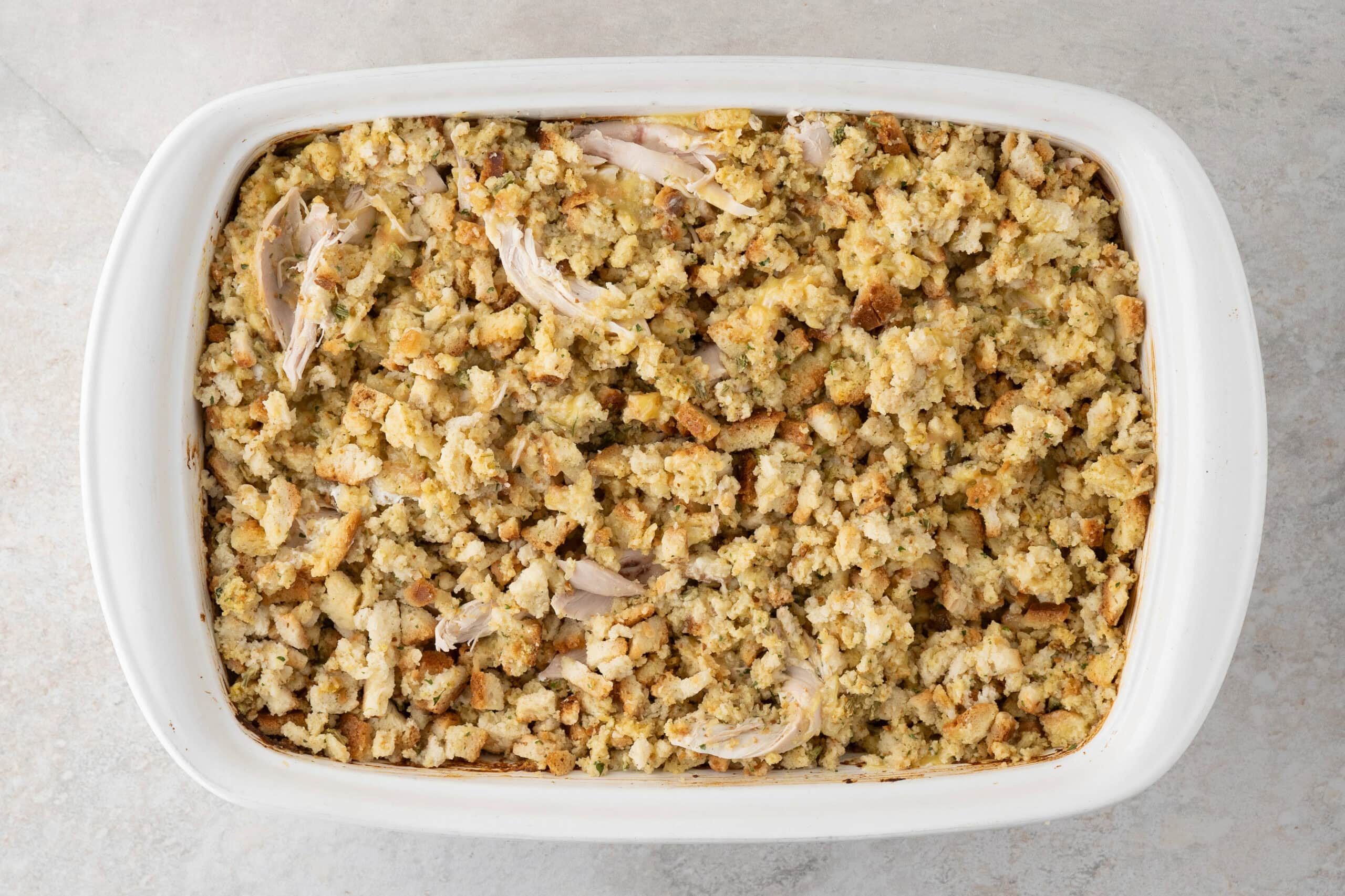 All ingredients in a baking dish to bake stove top stuffing and rotisserie chicken